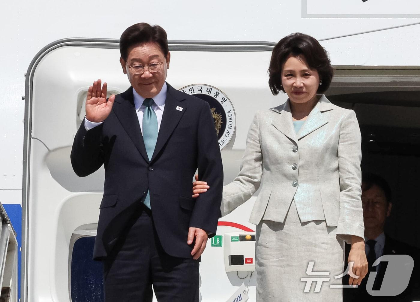 본문 이미지 - G7 정상회의 참석차 유럽 순방 일정에 나선 이재명 대통령과 김혜경 여사가 9일(현지시간) 벨기에 멜스브루크 군공항에 도착해 환영객들에게 인사하고 있다. 2026.6.9 ⓒ 뉴스1 허경 기자