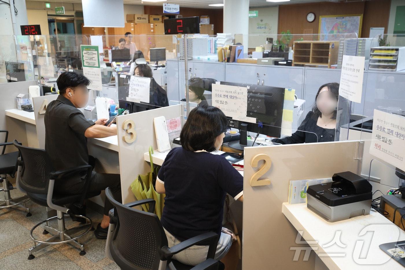 본문 이미지 - 전남광주통합특별시가 출범한 1일 오전 9시 전남광주 서구 치평동 행정복지센터에서 시민들이 신분증 발급을 위해 서류를 작성하고 있다 2026.7.1 ⓒ 뉴스1 조수민 수습기자