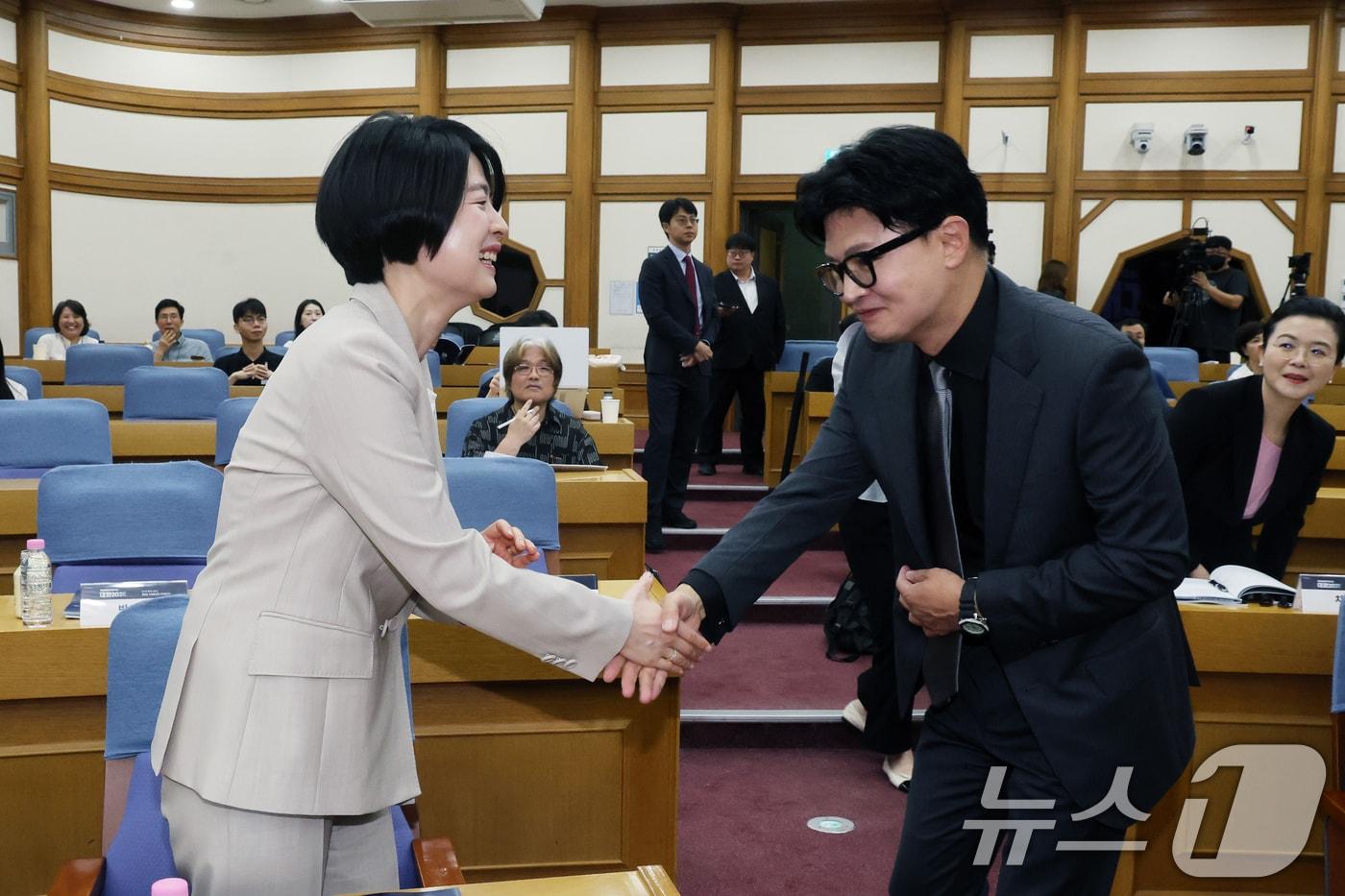 본문 이미지 - 한동훈 무소속 의원과 한지아 국민의힘 의원이 1일 오전 서울 여의도 국회 의원회관에서 열린 '국민통합컨센서스 대화 2026'에서 악수를 나누고 있다. 2026.7.1 ⓒ 뉴스1 황기선 기자