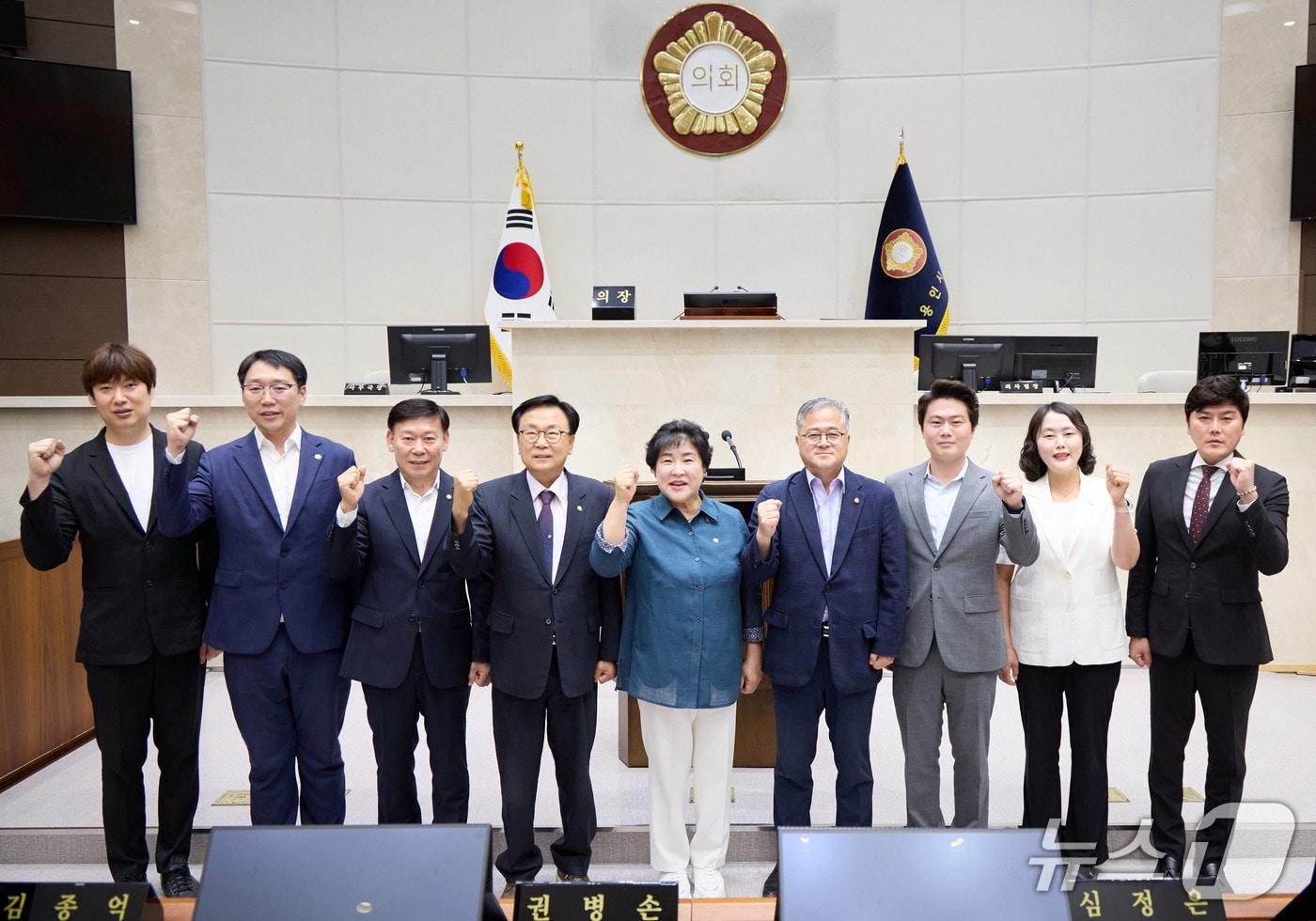본문 이미지 - 장정순 의장(가운데)과 김길수 부의장(오른쪽 네번째), 각 상임위원장, 여야 대표의원 등이 1일 임시회 본회의가 끝난 뒤 의회 본회의장에서 기념촬영을 하고 있다.(시의회 제공)