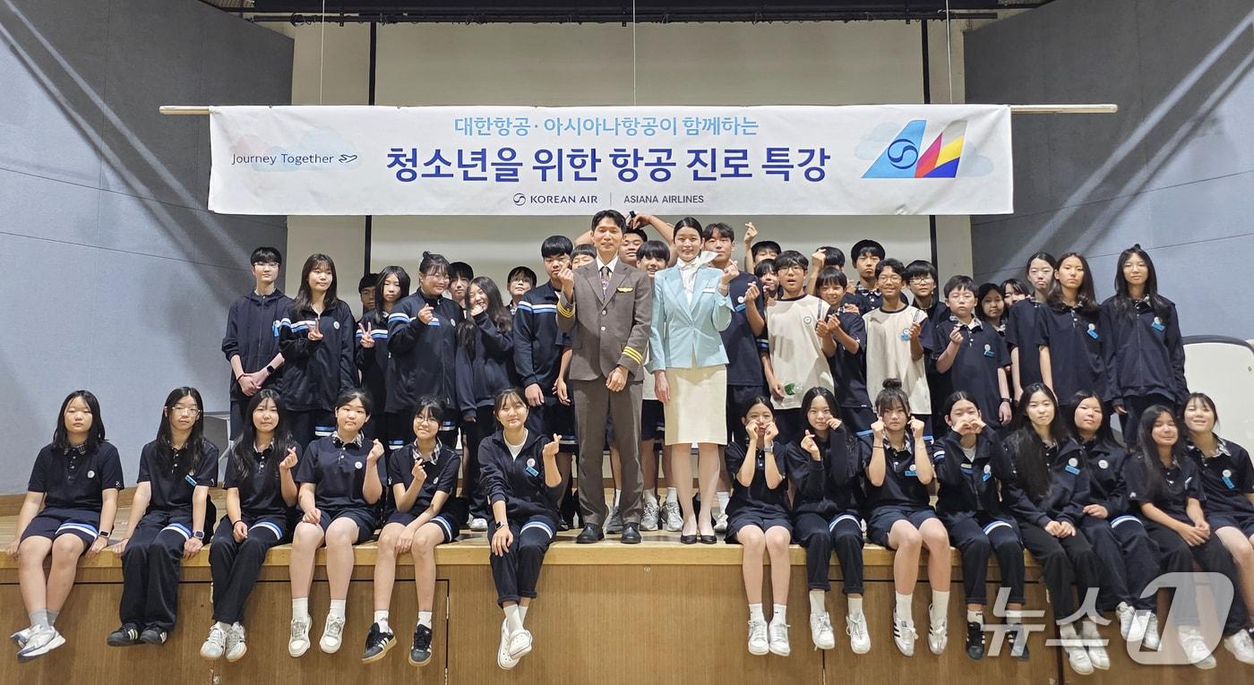 본문 이미지 - 지난 9일 대한항공·아시아나항공 교육기부 봉사단이 서울 성동구 한양대학교 사범대학 부속중학교에서 항공 진로 특강을 실시한 뒤 학생들과 기념 사진을 촬영한 모습(대한항공 제공). 2026.7.9.