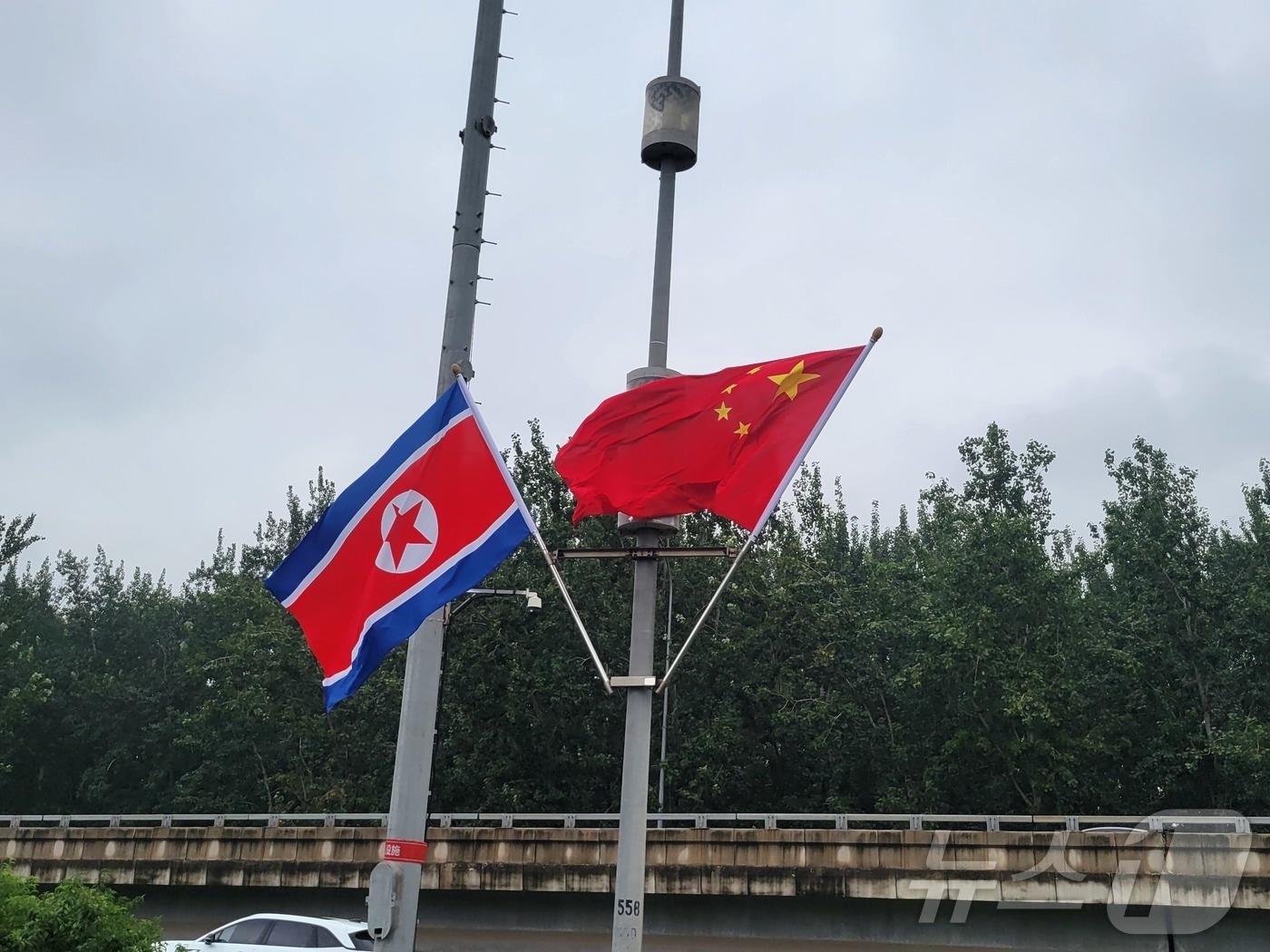 본문 이미지 - 박태성 북한 내각총리의 중국 방문을 환영해 도로 양측에 중국 오성홍기와 북한 인공기가 걸려 있다. ⓒ 뉴스1 정은지 특파원