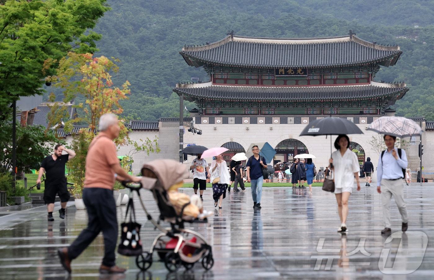 본문 이미지 - 비가 내린 10일 서울 종로구 광화문광장에서 시민들과 외국인 관광객들이 우산을 쓴 채로 발걸음을 옮기고 있다. 2026.7.10 ⓒ 뉴스1 김성진 기자