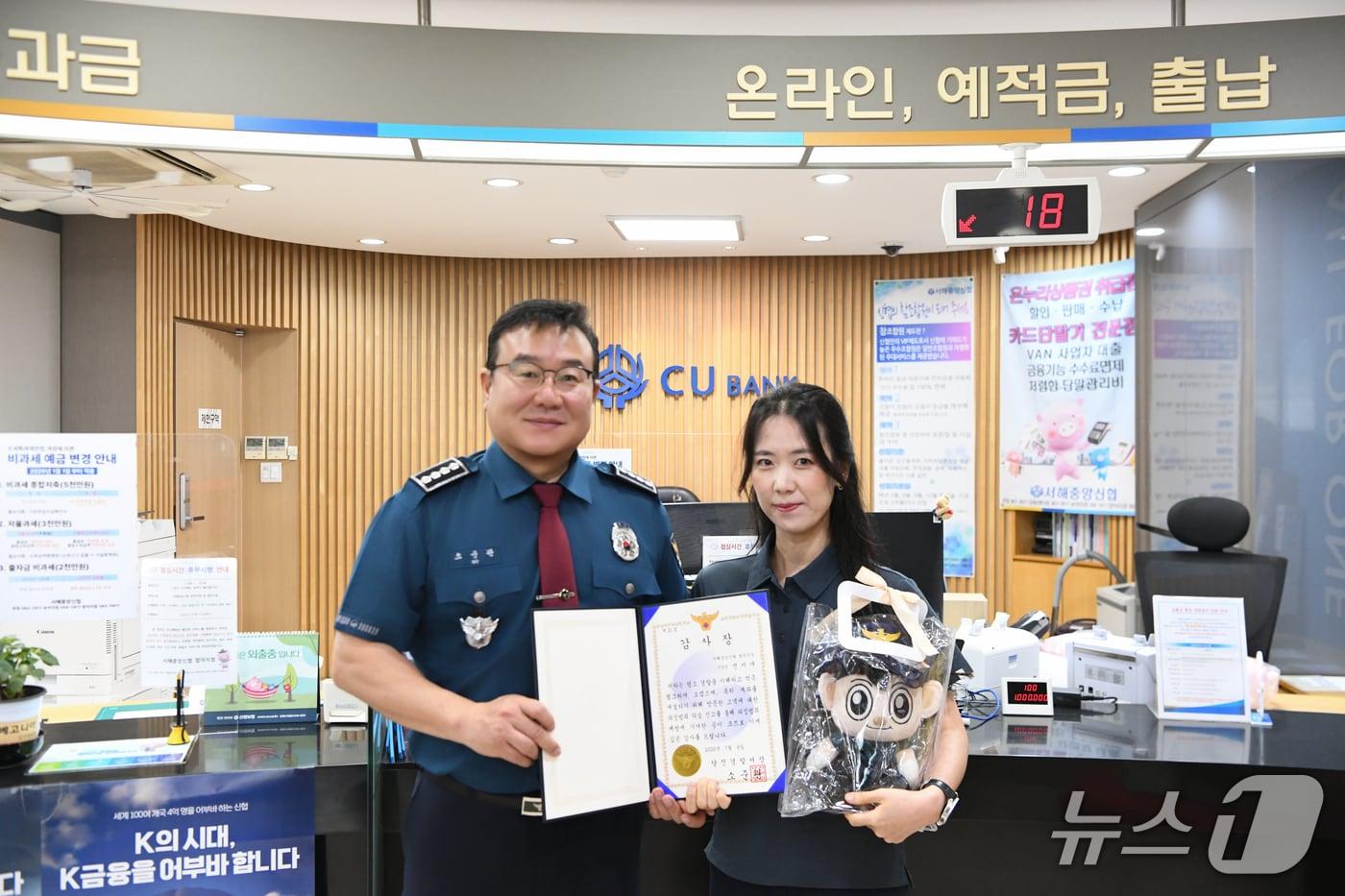 본문 이미지 -  전미애 서해중앙신협 당진 합덕지점장(오른쪽)이 소준관 당진경찰서장으로부터 감사장을 받고있다. (당진경찰서 제공, 재판매 및 DB금지) / 뉴스1