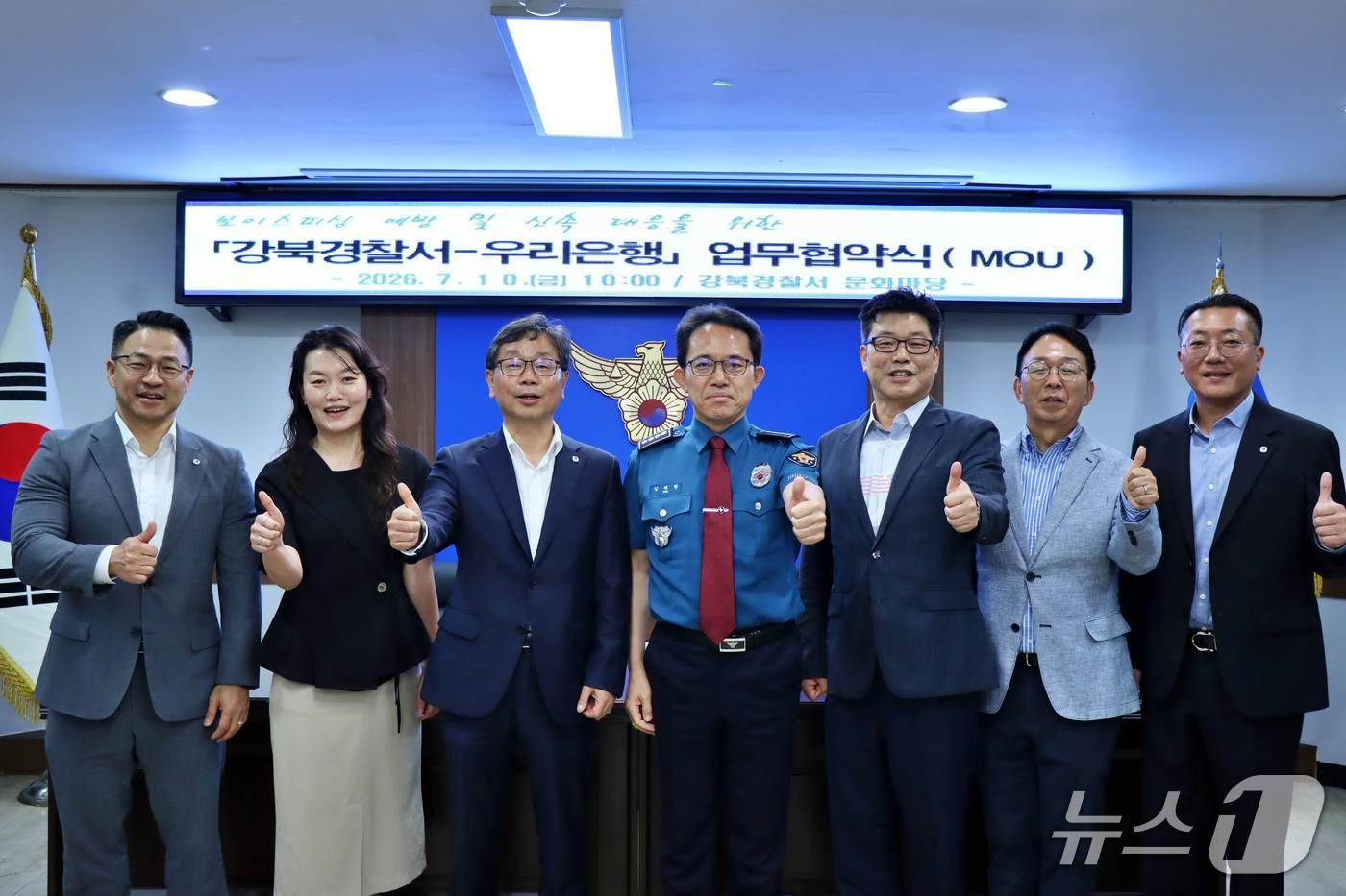본문 이미지 - 지난 10일 강북경찰서에서 전기통신 금융사기 피해 예방을 위해 열린 우리은행과 강북경찰서의 협약식에서 양 기관의 관계자들이 기념사진을 촬영하고 있다. (왼쪽부터) 우리은행 전재홍 금융사기예방총괄수석, 우리은행 전정현 금융사기예방팀장, 우리은행 김흥수 강북영업본부장, 김태현 강북경찰서장, 김태현 형사과장, 김정옥 수사과장, 우리은행 허재영 강북영업본부 부부장 2026.07.10 / 사진제공=우리은행