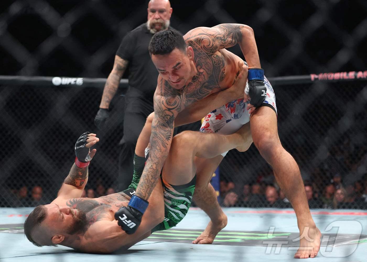 본문 이미지 - 코너 맥그리거(왼쪽)가 12일(한국시간) 열린 UFC 329 웰터급 메인 이벤트에서 맥스 홀로웨이에게 펀치를 허용하고 있다. ⓒ AFP=뉴스1