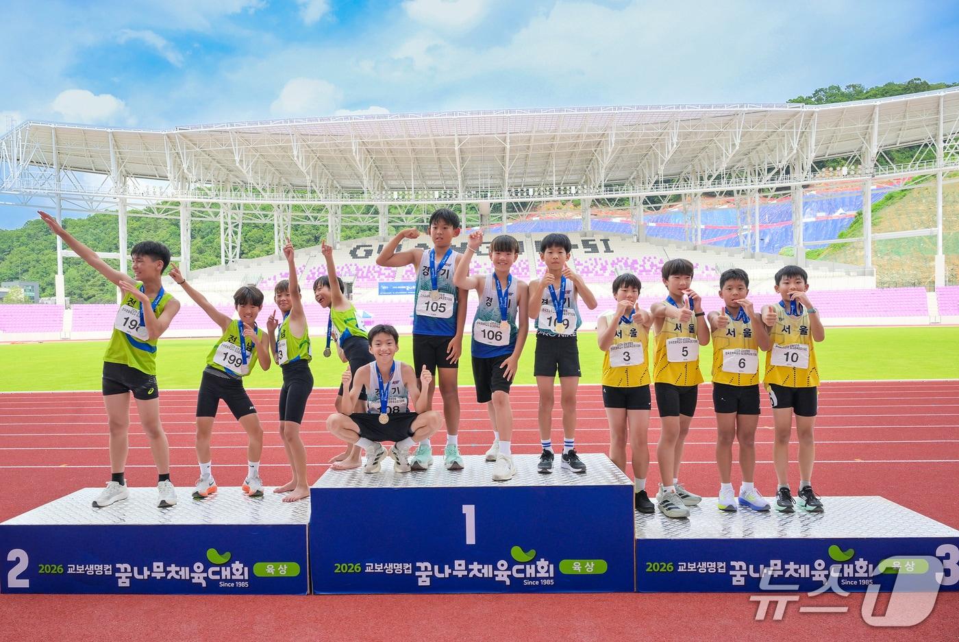 본문 이미지 - 지난 11일 경기도 광주시 G스타디움 육상경기장에서 열린 ‘제42회 교보생명컵 꿈나무체육대회’ 육상 4&times;100m 계주에서 1~3위를 차지한 선수들이 시상대에 올라 메달을 들고 기념촬영을 하고 있다./사진제공=교보생명