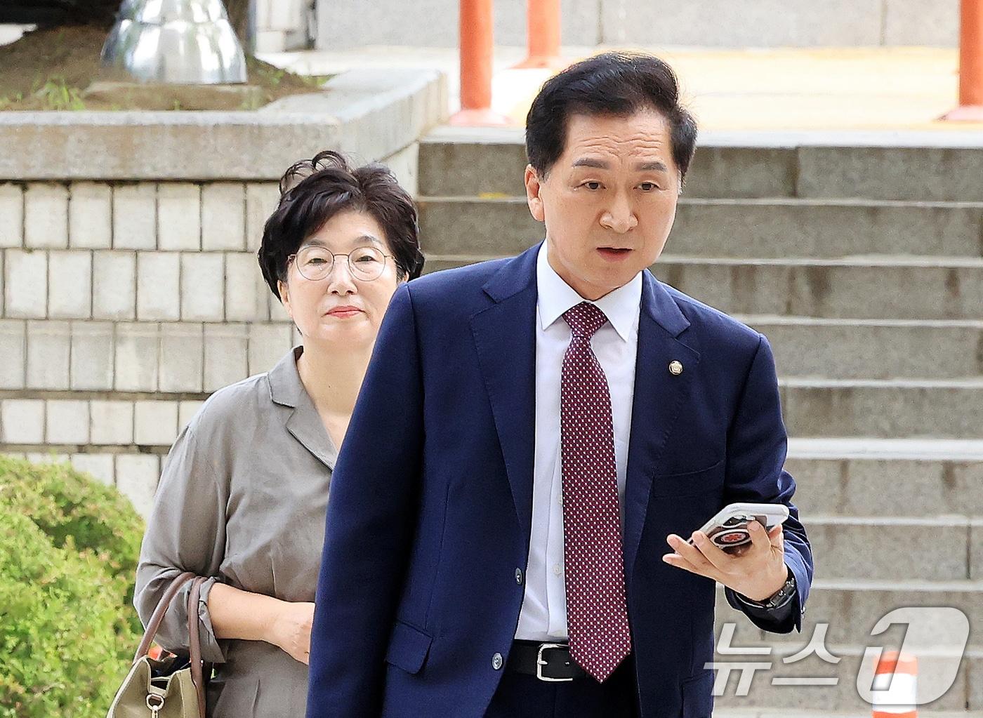 본문 이미지 - 청탁금지법 위반 혐의를 받는 김기현 국민의힘 의원과 부인 이 모 씨가 13일 서울 서초구 서울중앙지방법원에서 열린 청탁금지법 위반 1심 공판에 출석하고 있다. 김 의원은 배우자와 함께 지난 23년 3월에 열린 국민의힘 당대표 선거에서 통일교 신도들을 동원해 지원해준 대가로 같은 달 김 여사에게 '로저비비에 클러치백'을 제공한 혐의를 받고 있다. 2026.7.13 ⓒ 뉴스1 이호윤 기자
