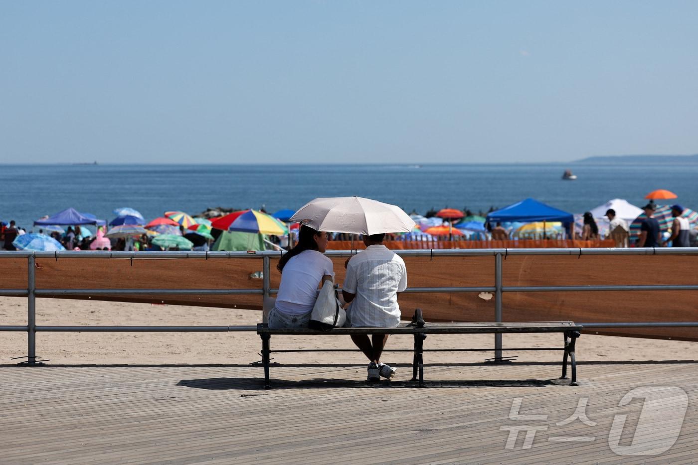 본문 이미지 - 4일(현지시간) 미국 뉴욕 브루클린 코니아일랜드에서 여름 폭염이 이어지자 시민들이 양산으로 햇볕을 가리고 있다.2026.07.04.ⓒ 로이터=뉴스1