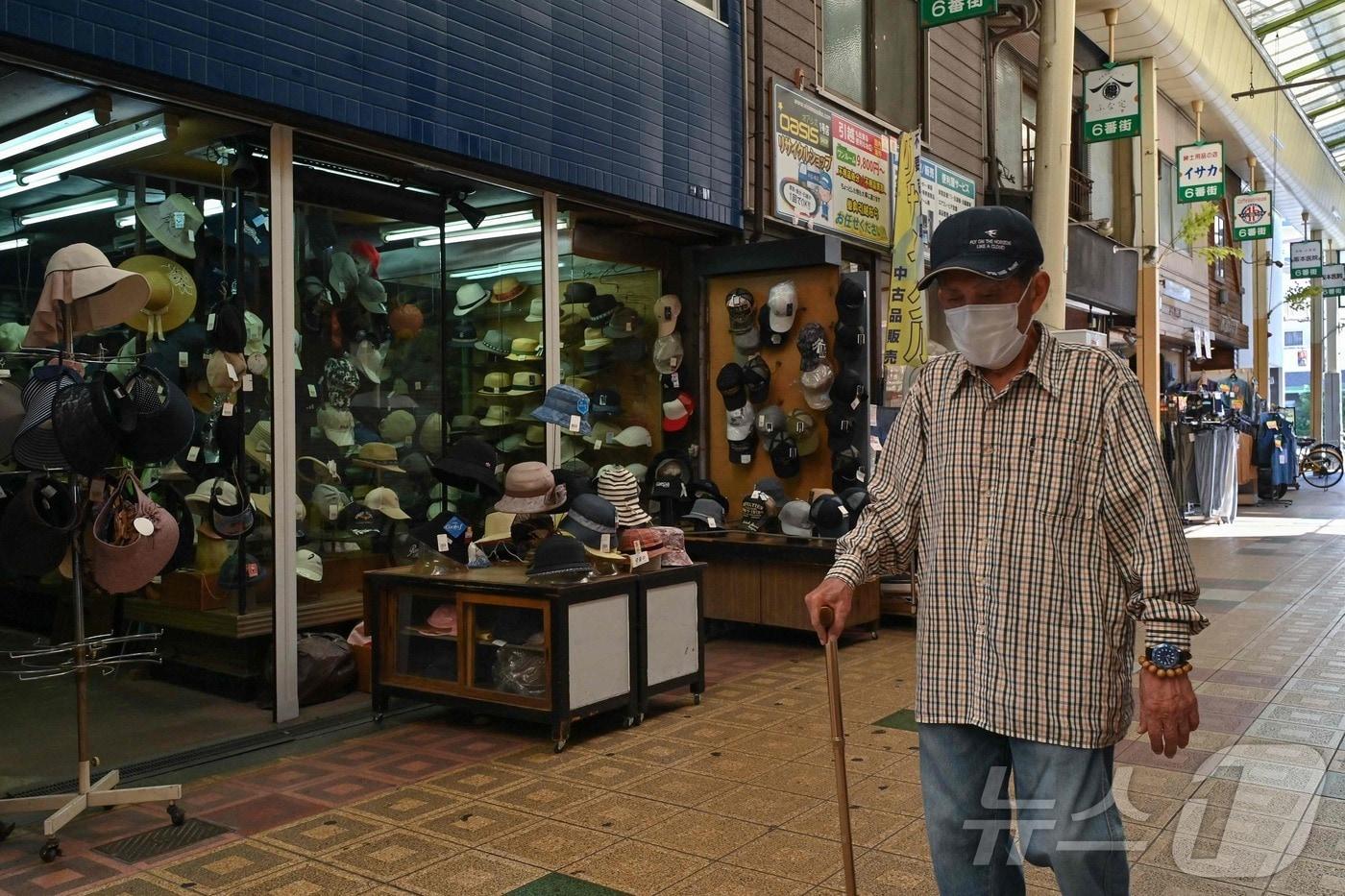 본문 이미지 - 2025년 10월 1일 일본 오사카 니시나리구의 쓰루미바시 상점가에서 한 노인이 걷고 있다. <자료사진> (사진은 기사 내용과 무관함) 2025.10.03. ⓒ AFP=뉴스1