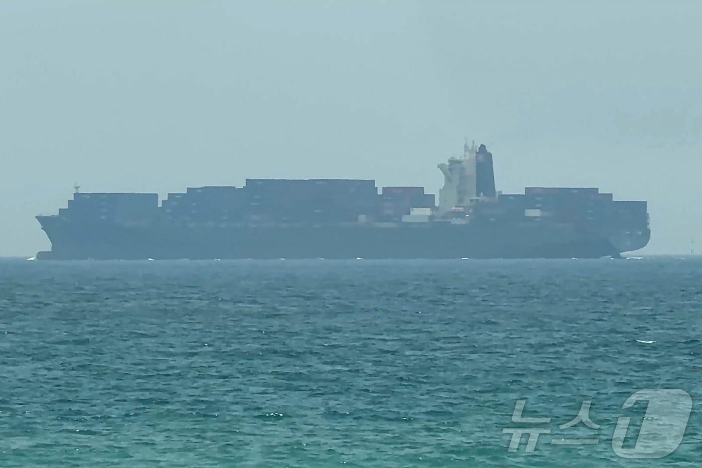 본문 이미지 - 12일(현지시간) 촬영된 AFP 영상 화면에서 한 화물선이 아랍에미리트 동부 해안 코르파칸 인근 호르무즈 해협에 정박해 있다.2026.07.12.ⓒ AFP=뉴스1