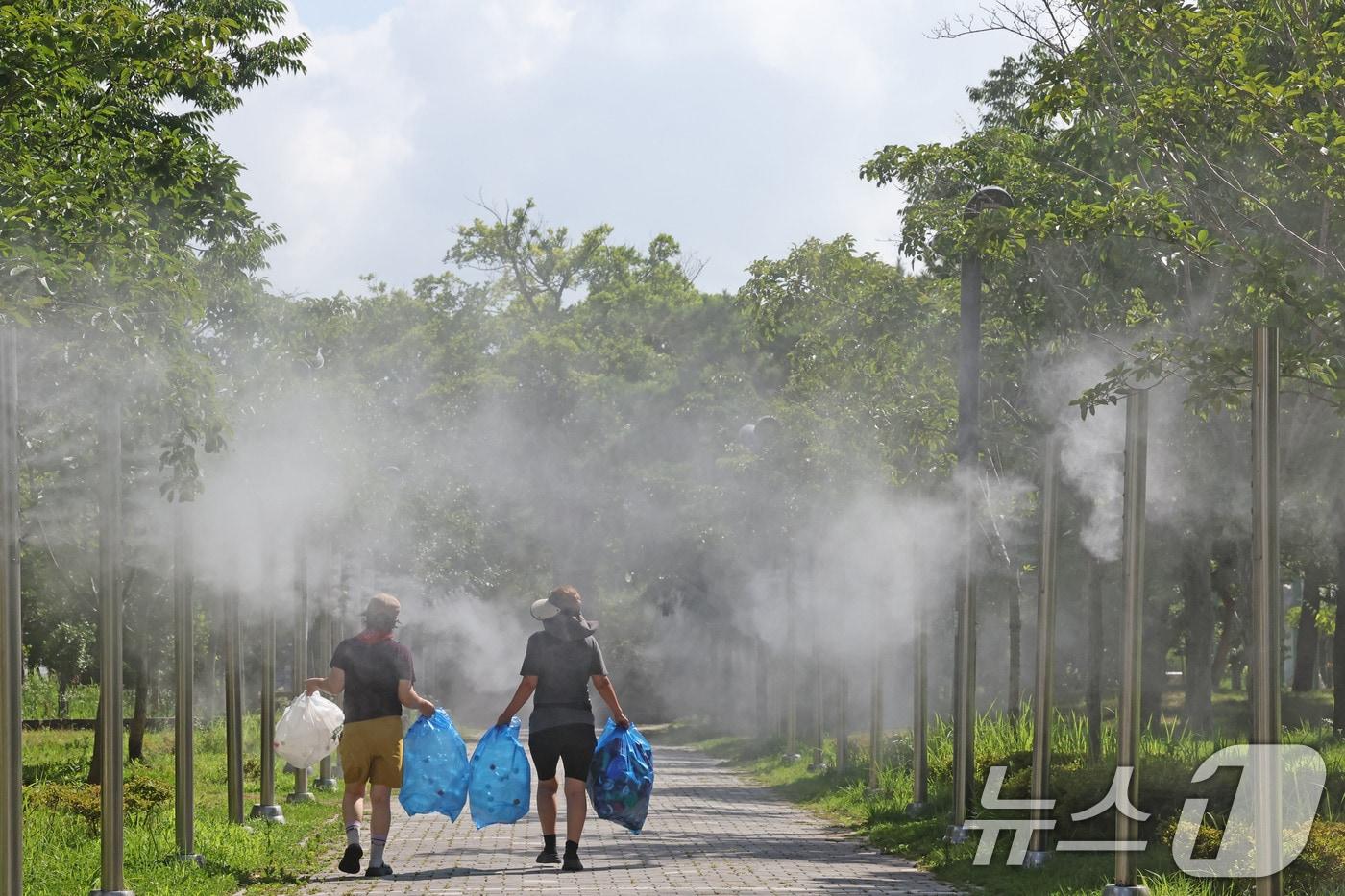 본문 이미지 - 낮 최고기온이 32.7도까지 오른 13일 전남광주통합특별시 서구 치평동 상무시민공원에서 시민들이 작동하는 쿨링포그를 맞으며 더위를 식히고 있다. ⓒ 뉴스1 박지현 기자