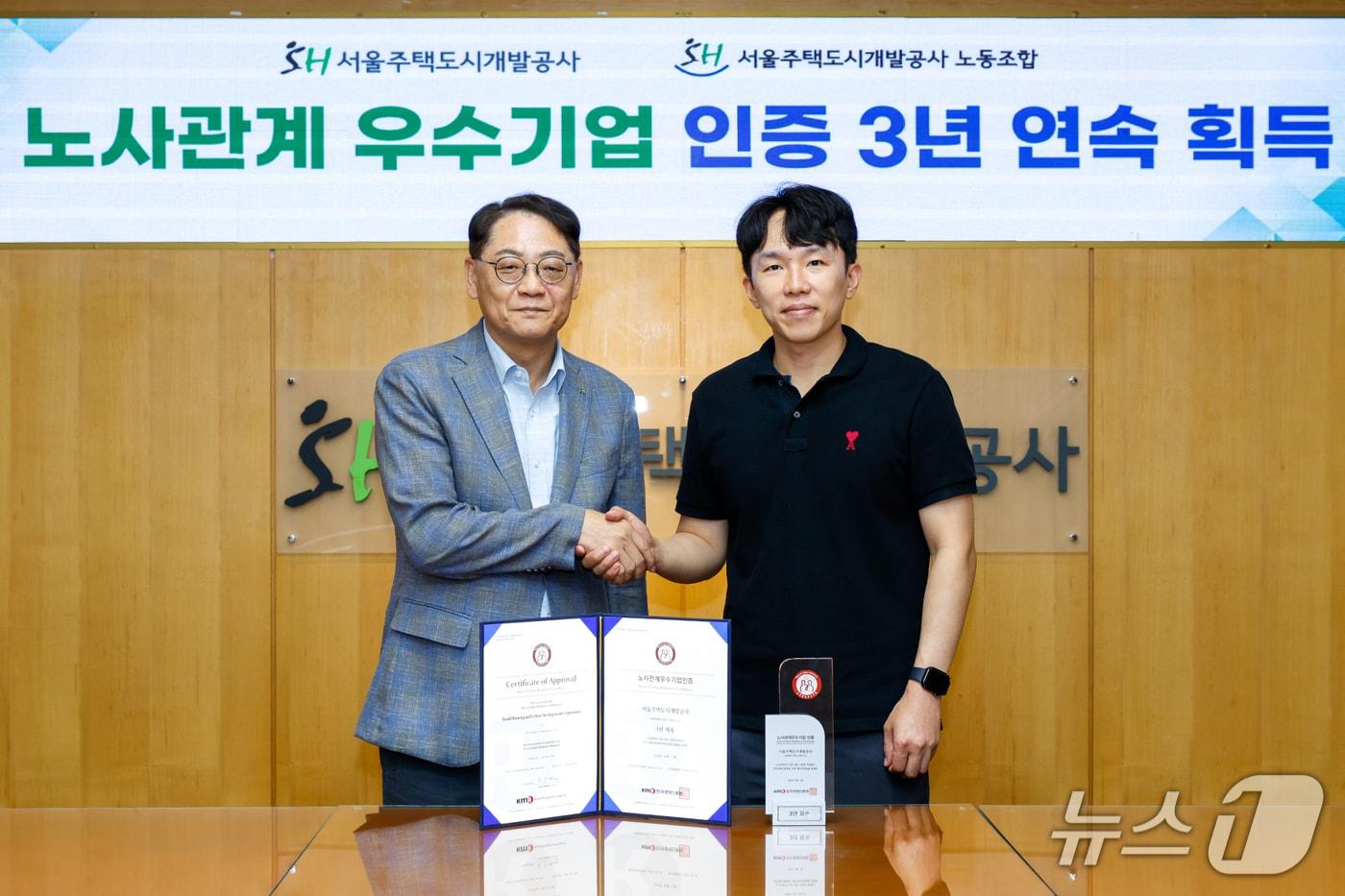 본문 이미지 - 황상하 서울주택도시개발공사(SH) 사장(왼쪽)과 남희철 SH노동조합 위원장이 3년 연속 노사관계우수기업 인증을 기념하며 악수하고 있다.(SH 제공)