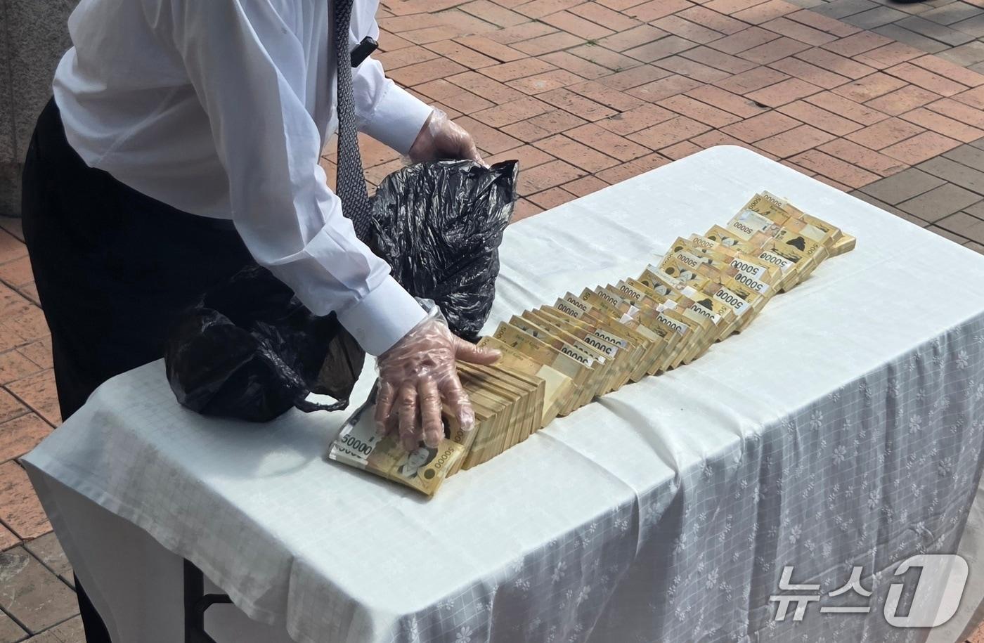 본문 이미지 - 부안의 한 민간 업체 대표 A 씨가 14일 오전 전북경찰청 앞에서 기자회견을 열고 권익현 부안군수 측근으로부터 받았다고 주장하는 현금 3억원을 꺼내 보이고 있다.2026.7.14/뉴스1 문채연 기자