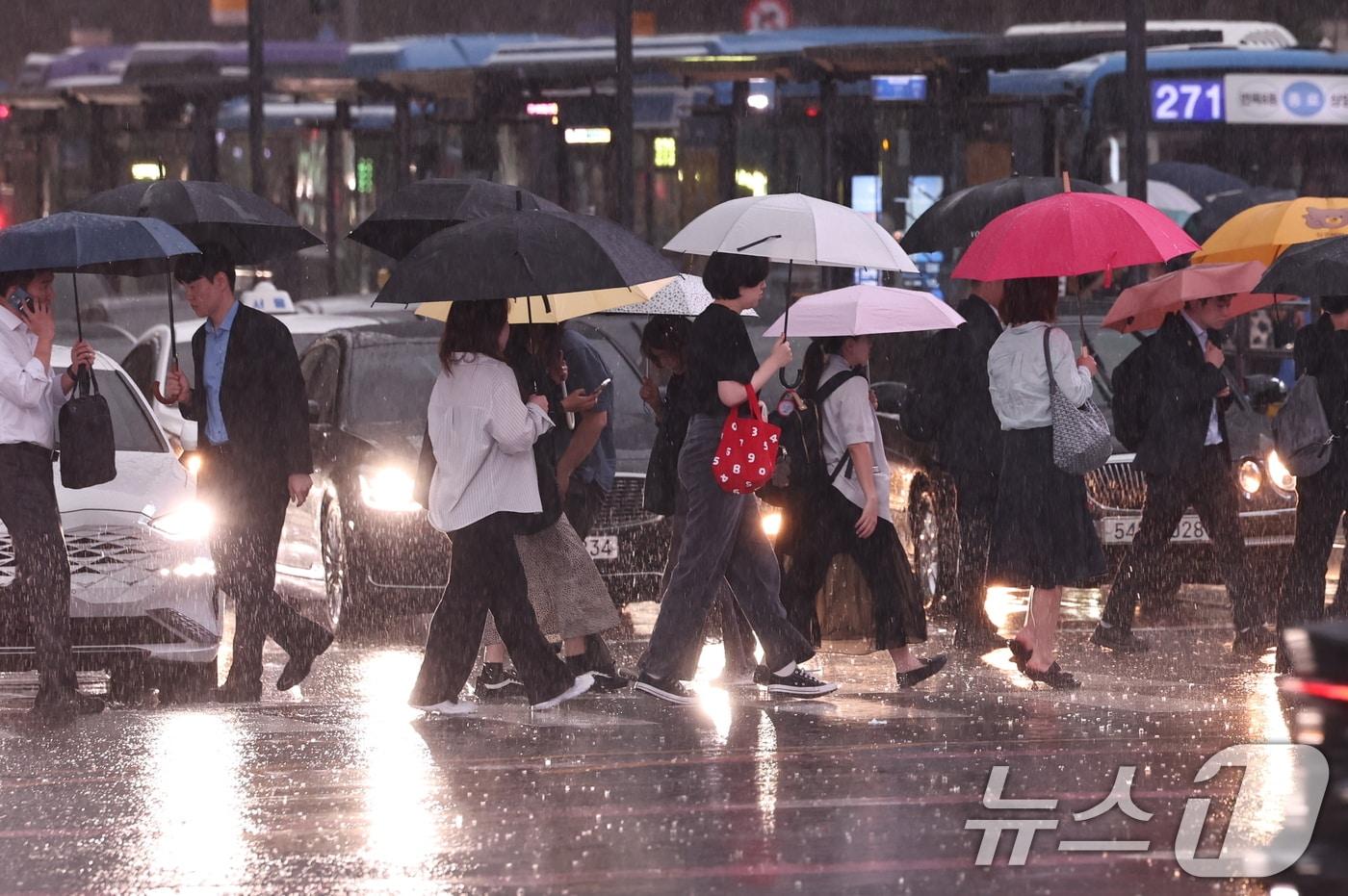 본문 이미지 - 수도권 곳곳에 호우주의보가 내려진 14일 오후 서울 종로구 광화문 네거리에서 시민들이 강한 빗줄기 속 퇴근길 발걸음을 재촉하고 있다. 2026.7.14 ⓒ 뉴스1 구윤성 기자