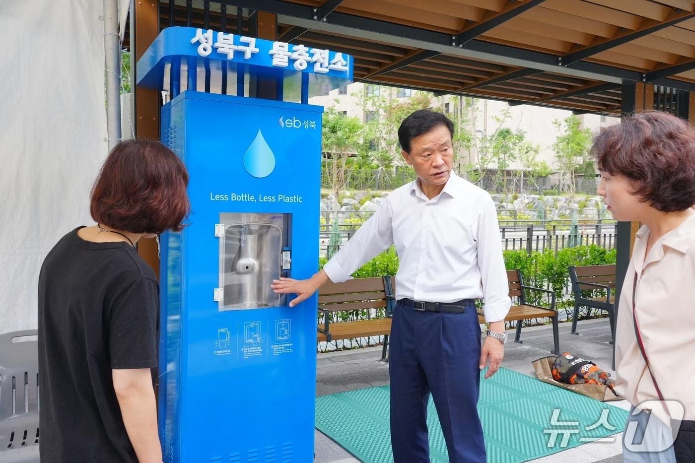 본문 이미지 - 이승로 성북구청장이 '성북구 물 충전소' 사용 방법을 구민에게 안내하고 있다.(성북구 제공)
