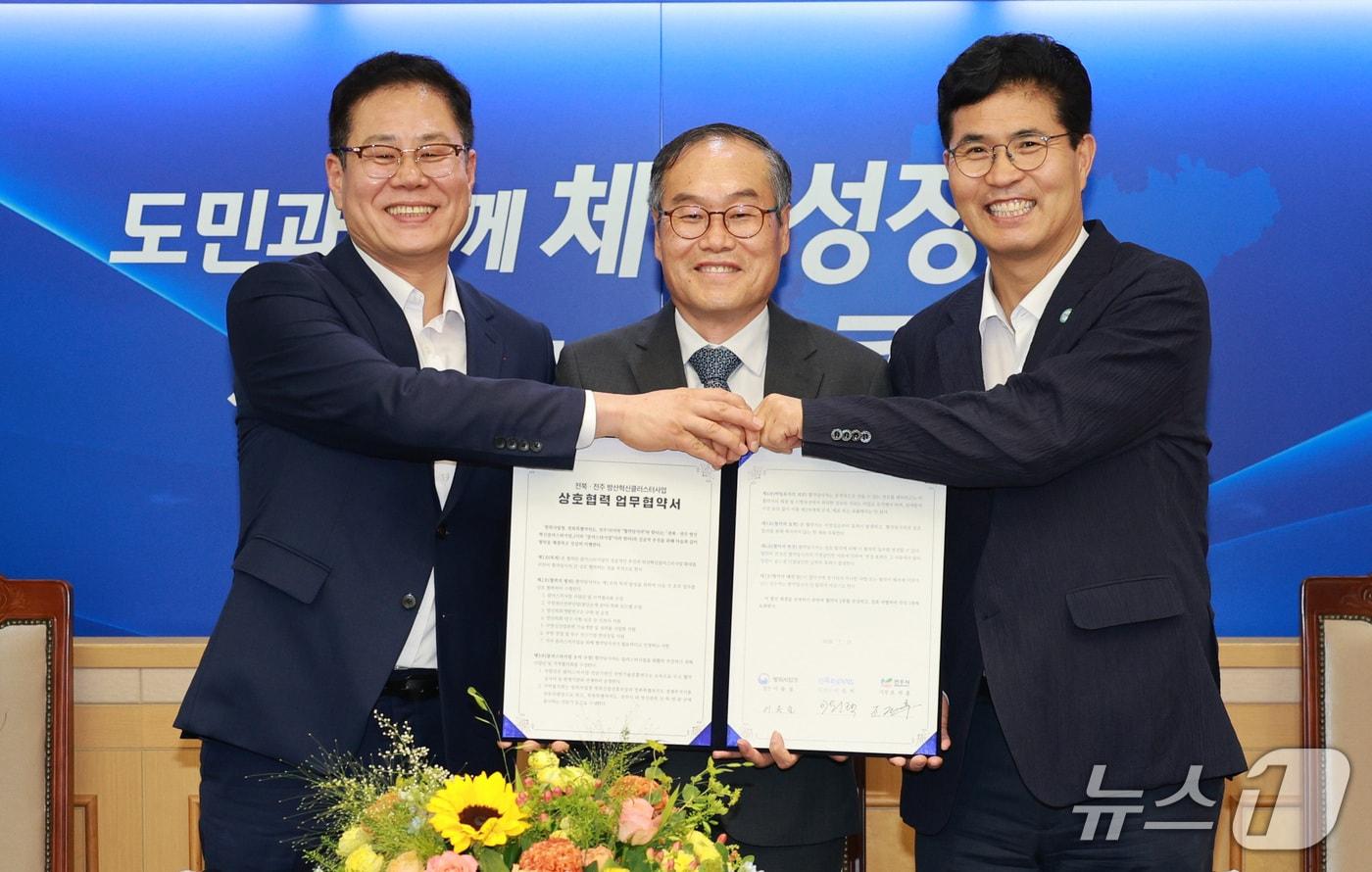 본문 이미지 - 15일 전북도청 회의실에서 전북 전주 방산혁신클러스터 사업 업무협약식이 개최된 가운데 이원택 도지사(오른쪽)와 이용철 방위사업청장(가운데), 조시훈 전주시장이 기념 촬영을 하고 있다.(전북도 제공. 재판매 및 DB금지)/뉴스1