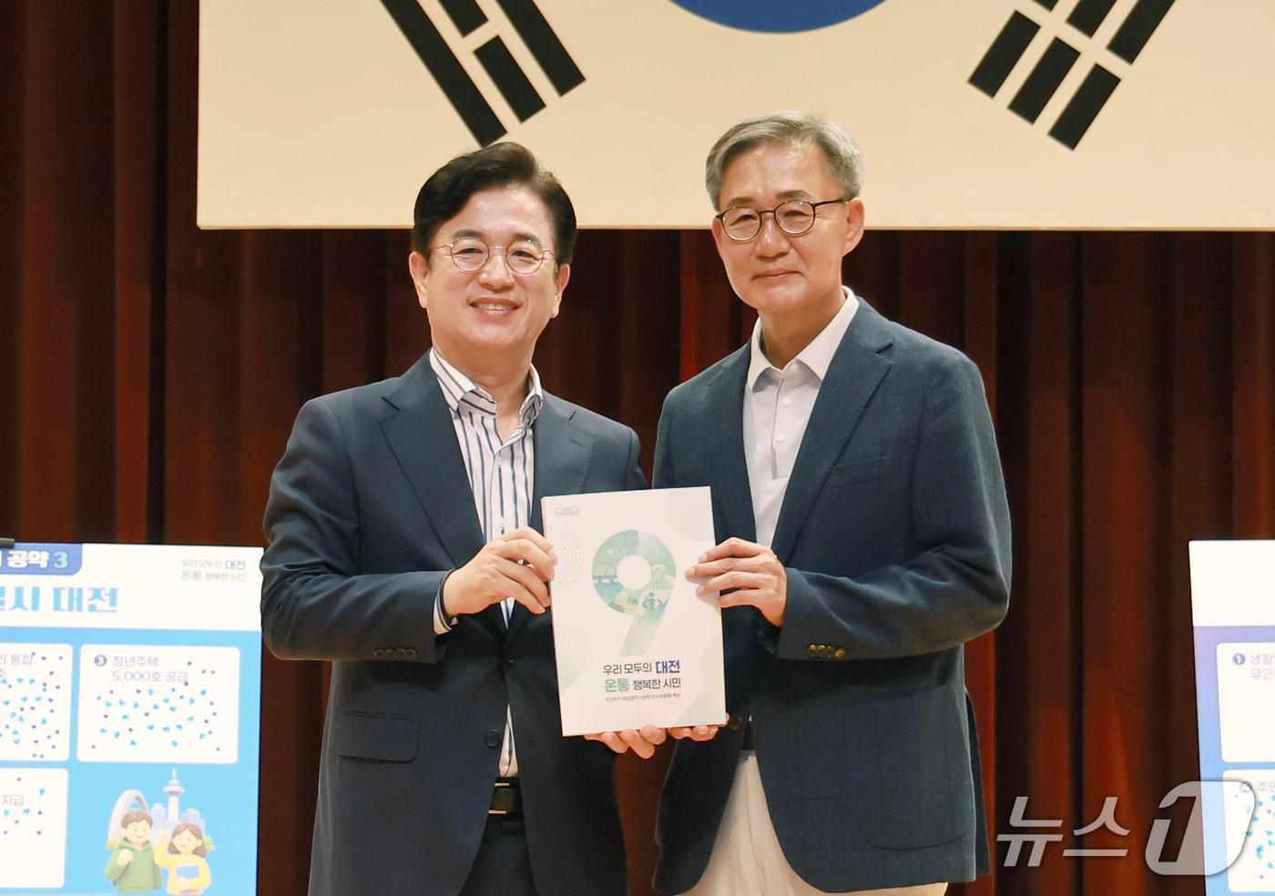 본문 이미지 - 대전시장직 인수위 이은구 부위원장(오른쪽)이 14일 오전 시청 대강당에서 열린 '민선 9기 인수위원회 해단식 및 성과보고회'에서 허태정 시장에게 백서를 전달하고 있다. (시 제공) / 뉴스1