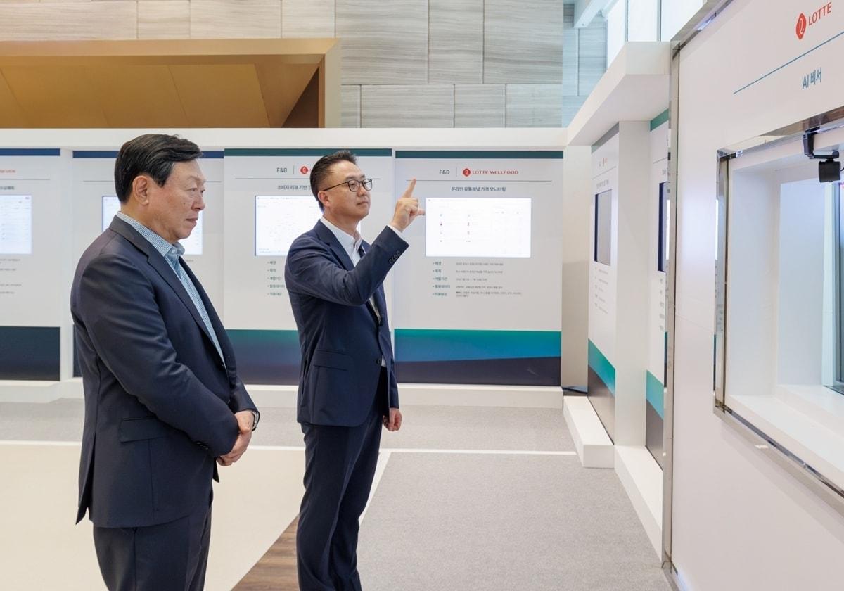 본문 이미지 - 15일 서울 롯데월드타워에서 2026년 하반기 VCM이 진행되기 앞서 신동빈 롯데 회장(왼쪽)이 황민재 롯데지주 경영혁신실장(오른쪽)으로부터 음성과 모션 인식 기반 'AI 비서'에 대한 설명을 듣고 있다. (롯데 제공)