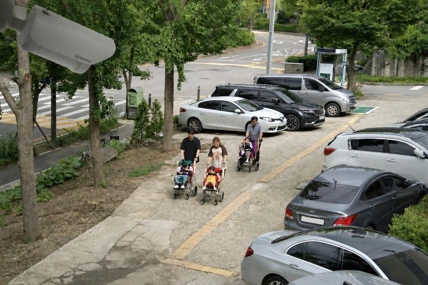 본문 이미지 - 휠체어를 타고 '동심원'으로 향하는 아이들과 직원들을 안전하게 비추는 한화비전의 AI 카메라. (한화비전 제공)