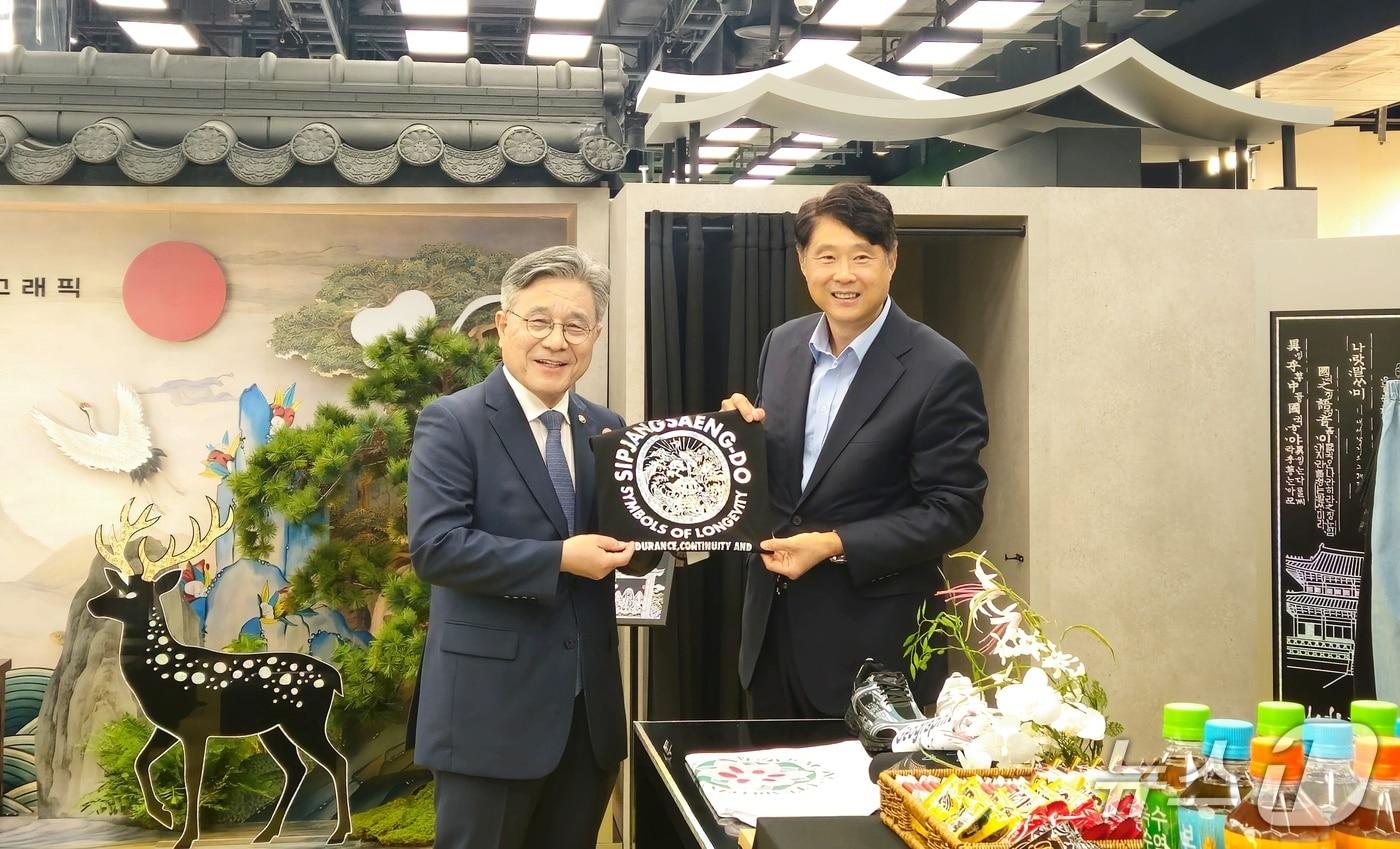 본문 이미지 - 박영준 더네이쳐홀딩스 대표(오른쪽)와 허민 국가유산청장이 16일 오전 더현대 서울 'K-헤리티지 팝업스토어'에서 전통 문양이 그려진 티셔츠를 들고 기념 촬영을 하고 있다. ⓒ 뉴스1 박혜연 기자