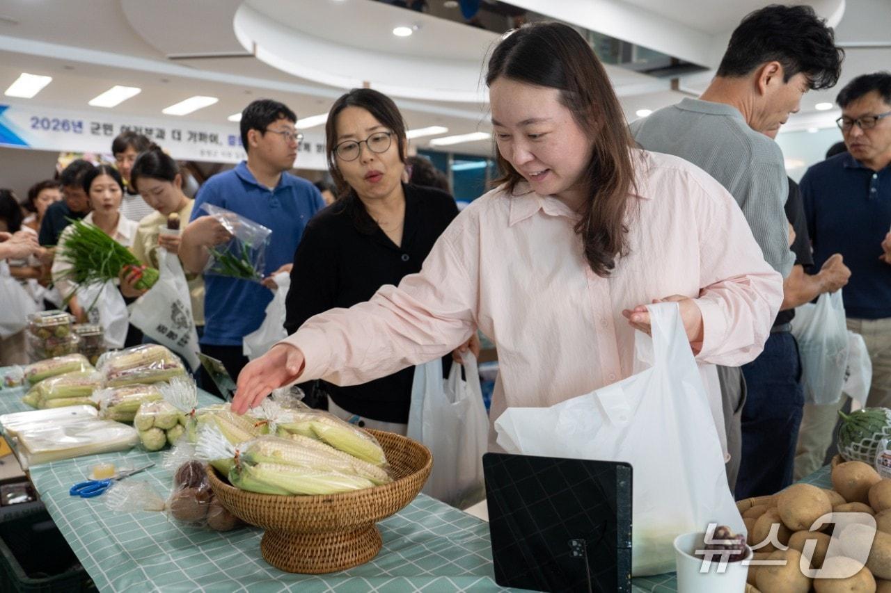본문 이미지 - 증평군청에 마련한 농산물 적거래 판매장을 찾은 주민이 농산물을 고르고 있다.(증평군 제공. 재판매 및 DB금지)/뉴스1
