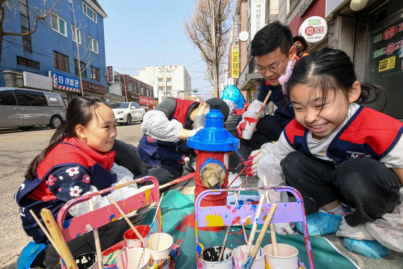본문 이미지 - 현대모비스 임직원들이 자녀들과 함께 수도권 일대에서 소화전 도색 활동을 펼치는 모습. 2024년 시작한 소화전 도색 활동으로 올해까지 누적 1000개의 소화전이 새단장될 예정이다(현대모비스 제공). 2026.7.16.