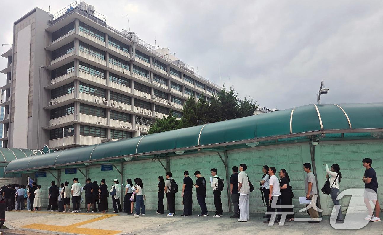 본문 이미지 - 지난 15일 서울 종로구 세종대로 주한미국대사관 앞에서 시민들이 비자 인터뷰를 위해 줄지어 서 있다. 2026.7.17 ⓒ 뉴스1 박세연 기자