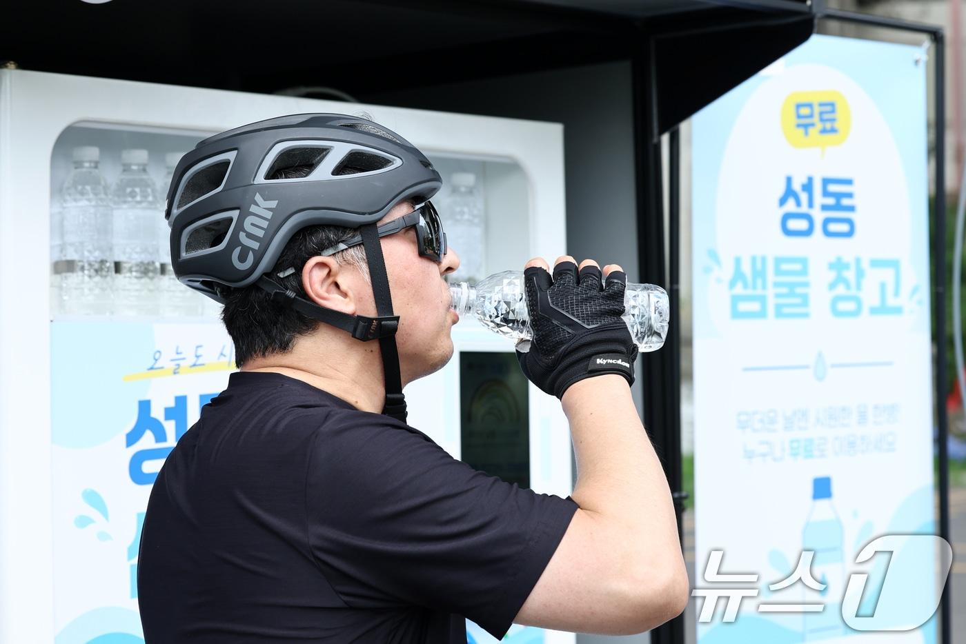 본문 이미지 - 17일 서울 성동구 응봉체육공원 인근에 마련된 성동 샘물 창고에서 시민들이 생수를 받아 마시고 있다.  2026.7.17 ⓒ 뉴스1 최지환 기자