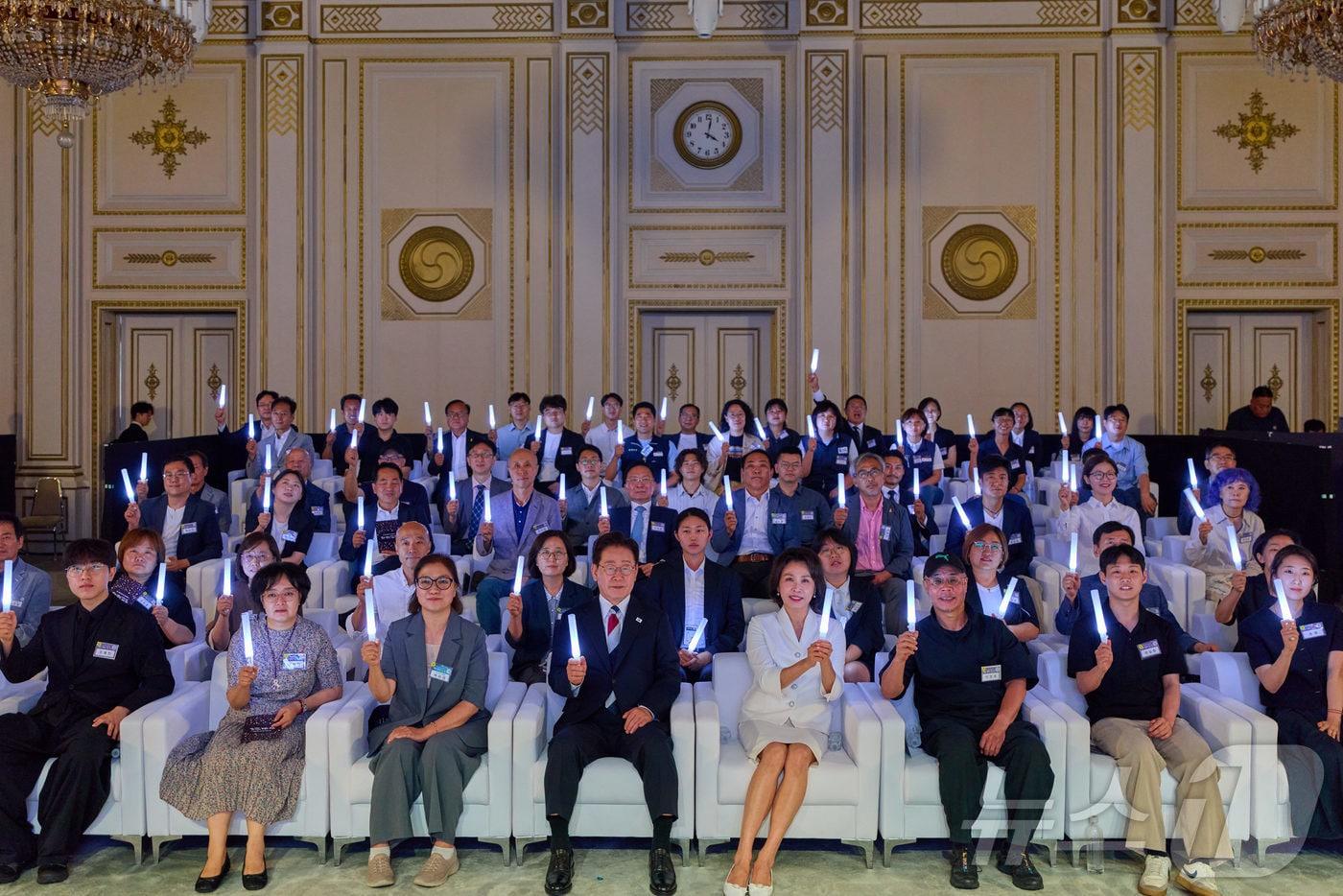 본문 이미지 - 이재명 대통령과 김혜경 여사가 17일 청와대 영빈관에서 열린 '빛의 위원회' 출범기념 시민초청행사에서 참석자들과 응원봉을 들고 기념촬영을 하고 있다. (청와대 제공. 재판매 및 DB 금지) 2026.7.17 ⓒ 뉴스1 허경 기자