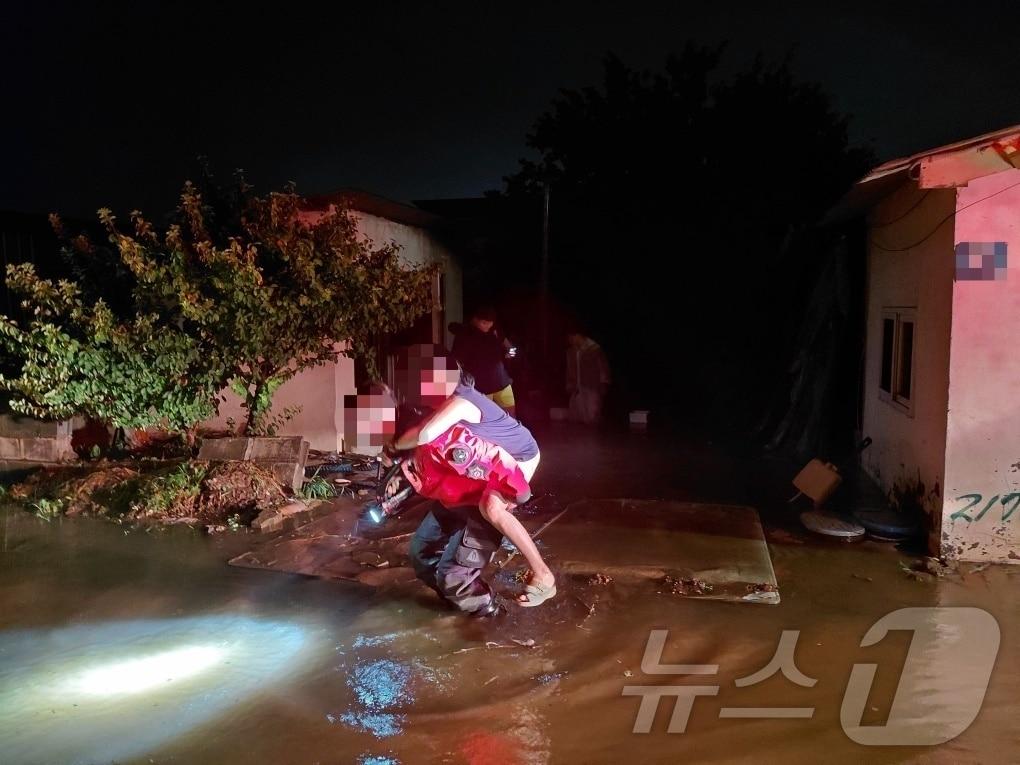 본문 이미지 - 17일 오후 8시 13분께 경북 구미시의 한 주택이 침수돼 60대 여성이 구조대원의 도움을 받아 대피하고 있다. 당시 함께 있던 다른 구조자 3명은 자력으로 탈출했다. (경북소방본부 제공. 재판매 및 DB 금지) ⓒ 뉴스1 이성덕 기자