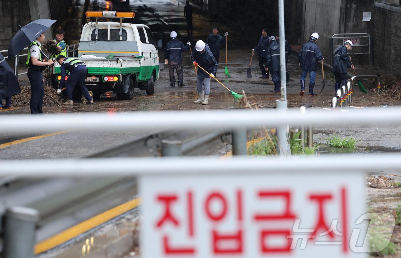 본문 이미지 - 새벽부터 수도권에 집중호우가 내린 18일 서울 서대문구 증산교 인근에서 경찰과 구청 관계자들이 도로 정비를 하고 있다. 2026.7.18 ⓒ 뉴스1 김성진 기자