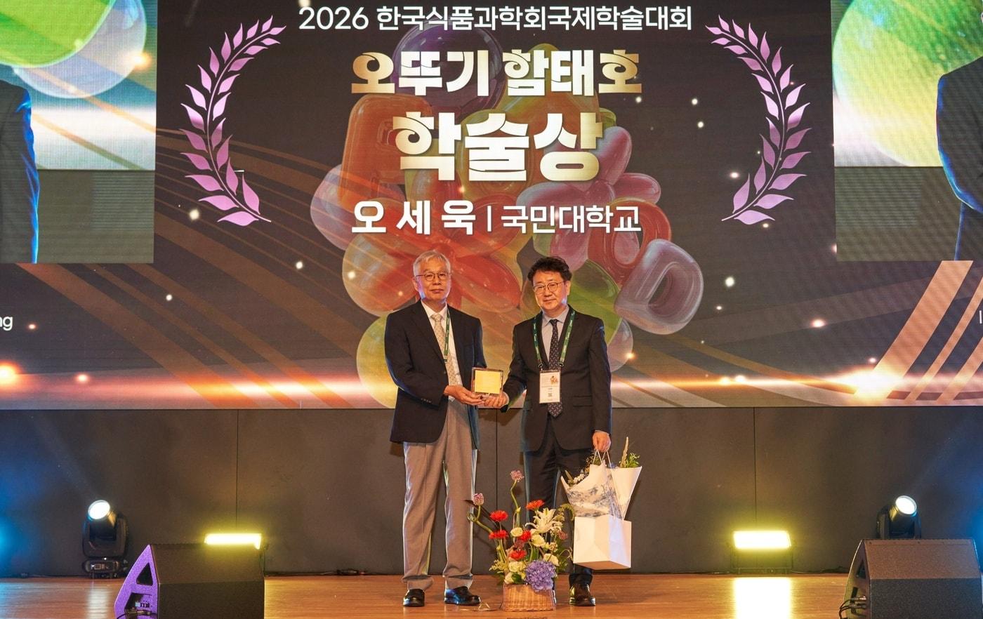 본문 이미지 - 2026 한국식품과학회 국제학술대회에서 박기문 오뚜기함태호재단 이사(왼쪽)와 오뚜기 함태호 학술상을 수상한 오세욱 국민대학교 교수가 기념촬영을 하고 있다.(오뚜기 제공)