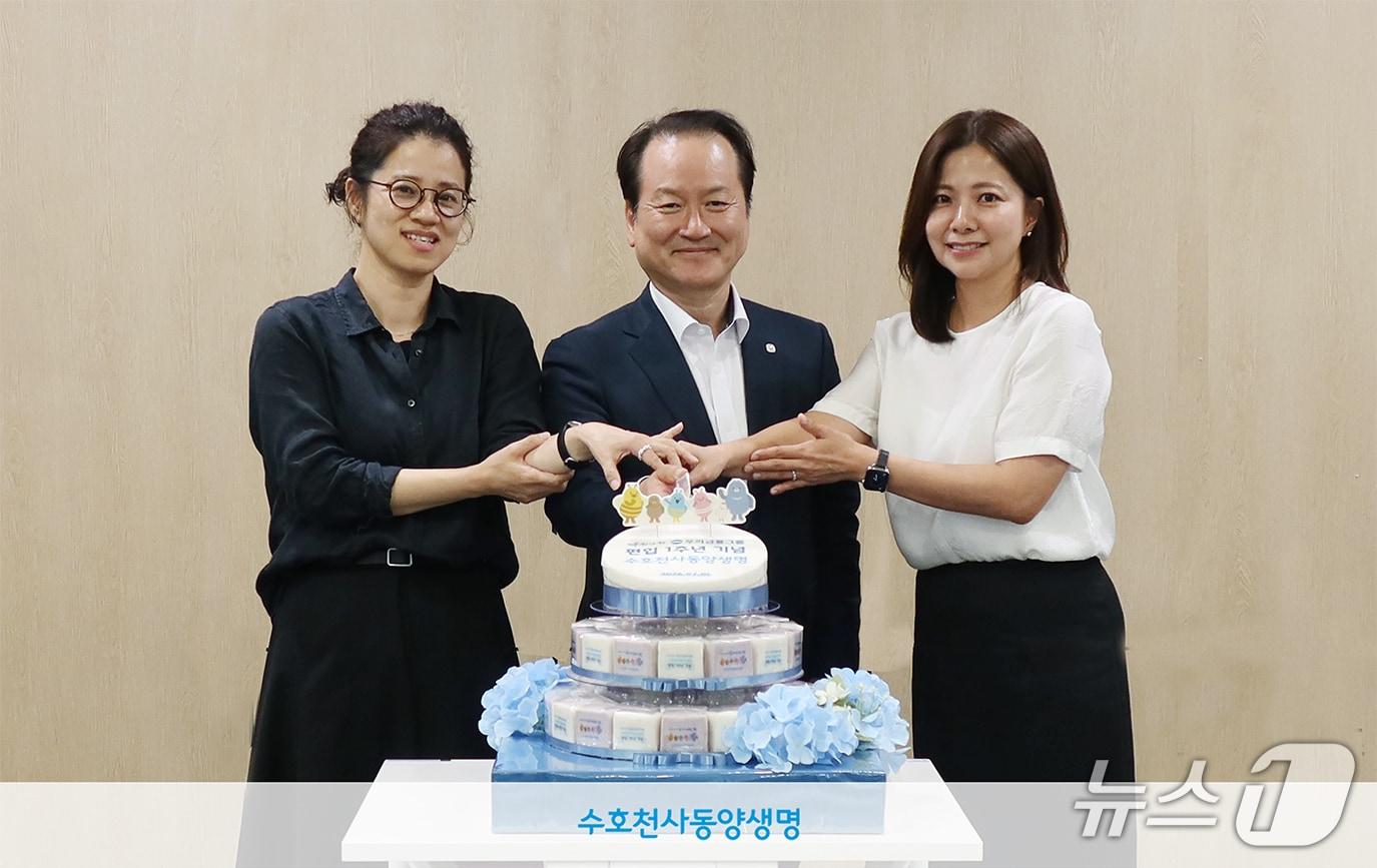 본문 이미지 - 동양생명 성대규 대표(가운데)가 지난 1일 열린 ‘돌잡이’ 콘셉트의 타운홀 미팅에서 직원들과 함께 기념 떡을 자르고 있다./사진제공=동양생명