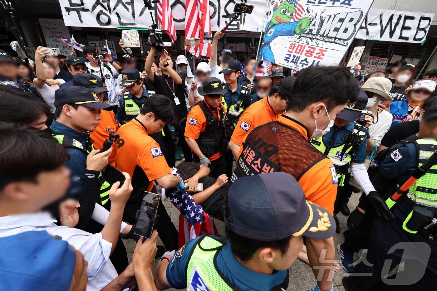 본문 이미지 - 2일 서울 송파구 올림픽공원 핸드볼경기장 개표소 앞에서 국조특위 현장조사를 앞두고 시위 참가자 간 충돌이 일어나 경찰과 구급대원이 현장을 수습하고 있다. 2026.7.2 ⓒ 뉴스1 구윤성 기자