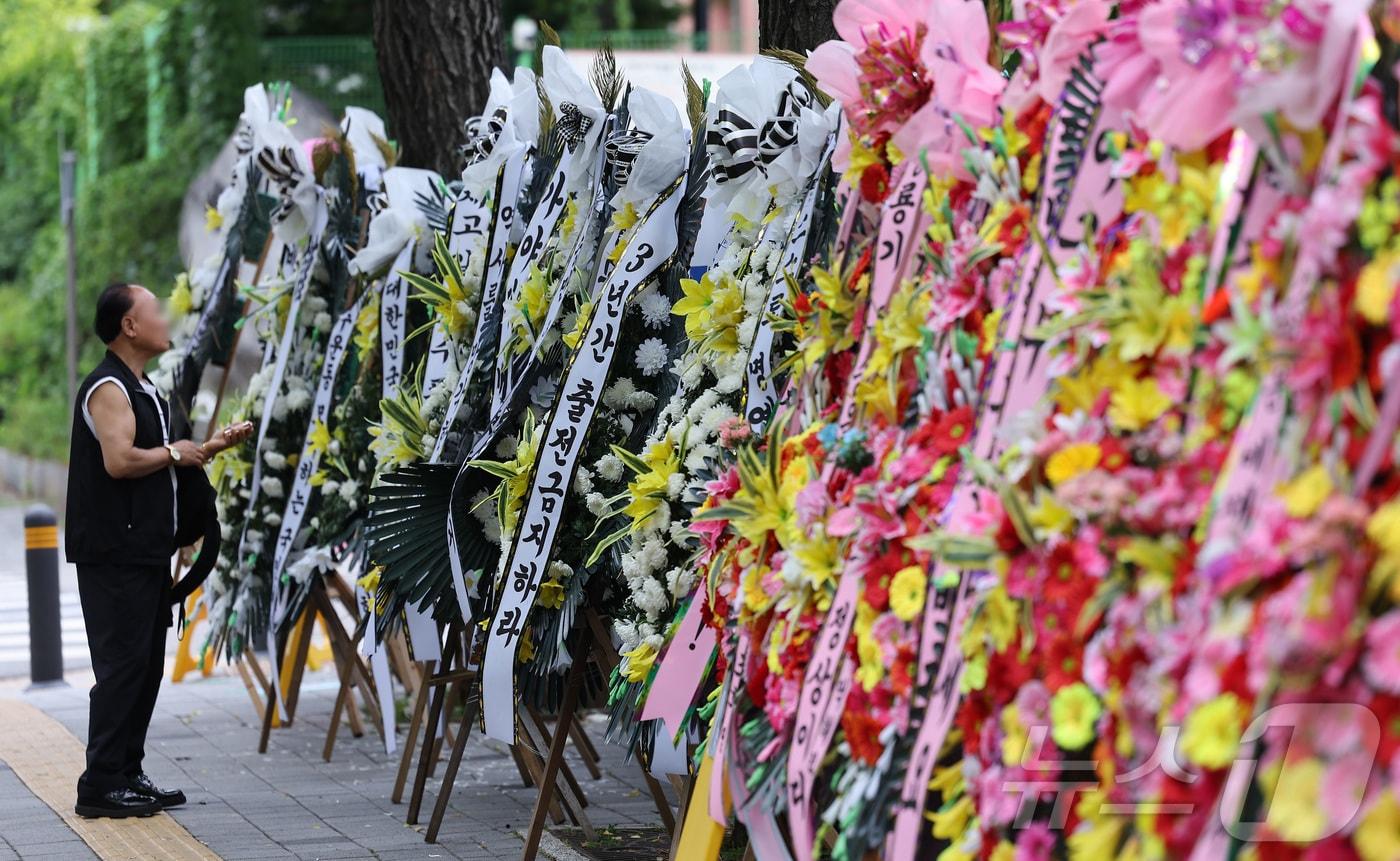 본문 이미지 - 2일 서울 강동구 배재고등학교 앞에 배재고등학교 야구부를 비판하는 근조화환과 응원하는 화환이 놓여 있다. 2026.7.2 ⓒ 뉴스1 김성진 기자