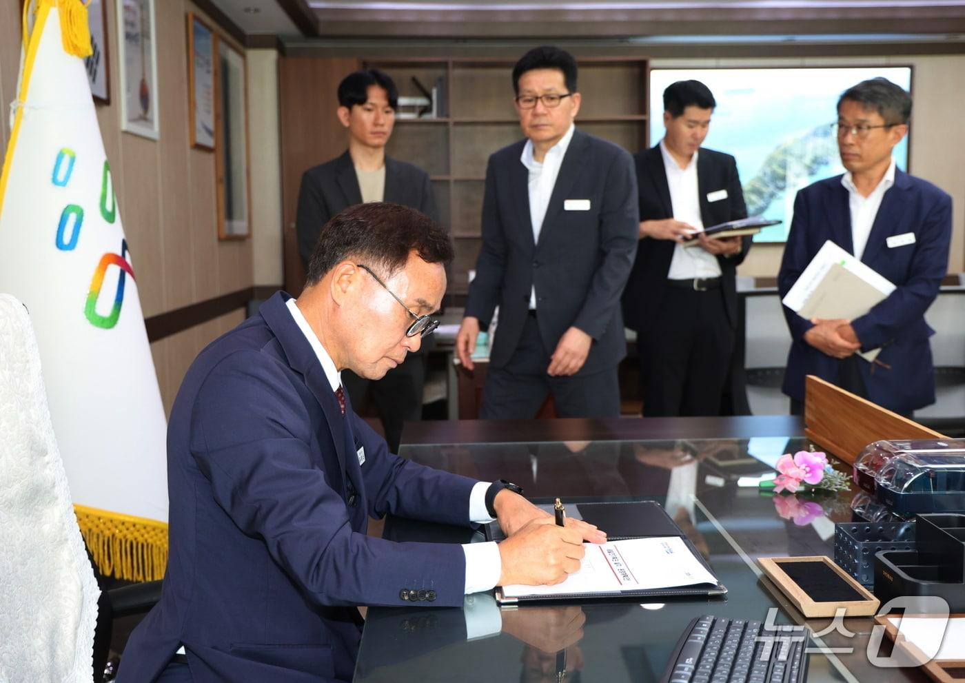 본문 이미지 - 윤희신 태안군수가 취임 첫날 세일즈기획단 설치·운영계획에 1호 결재를 하고 있다.(태안군 제공. 재판매 및 DB금지)/뉴스1