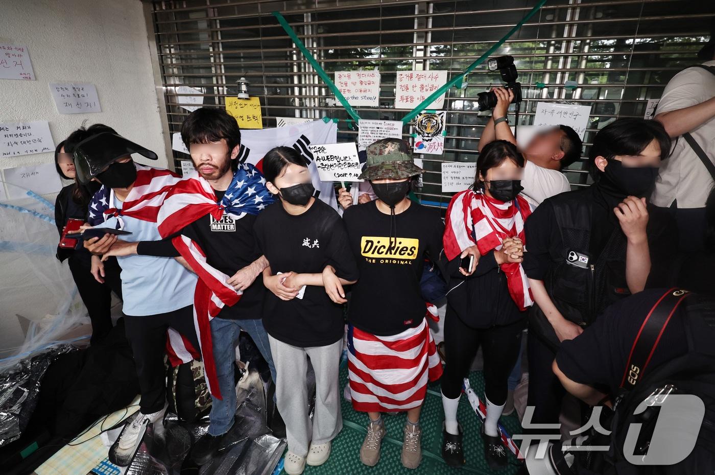 본문 이미지 - 2일 오후 국정조사특별위원회의 개표소 현장조사를 앞둔 서울 송파구 올림픽공원 핸드볼경기장에서 시위 참가자들이 스크럼을 짜며 출입구를 막고 있다. 2026.7.2 ⓒ 뉴스1 구윤성 기자