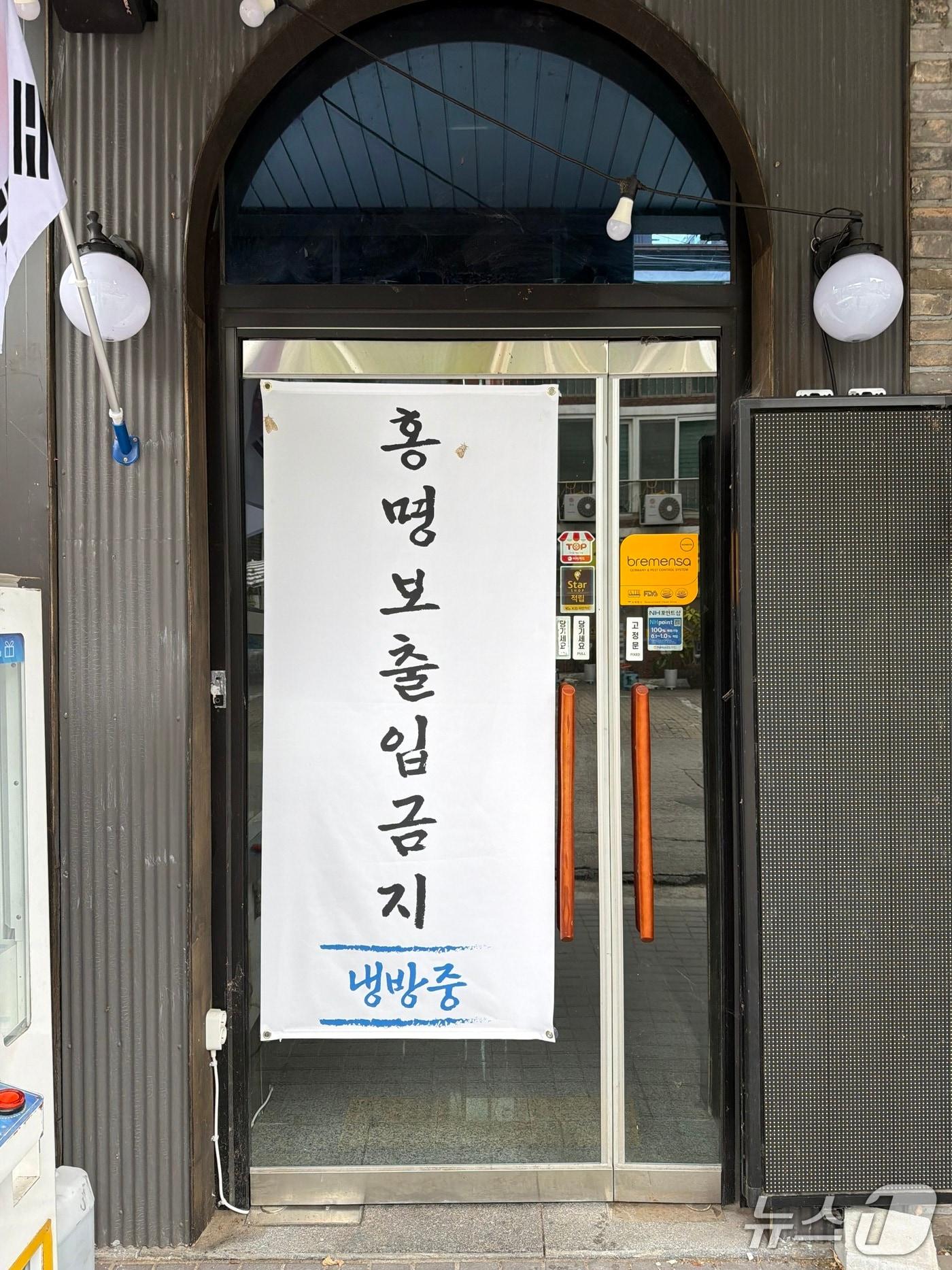 본문 이미지 - 강원 춘천  후평동 일대 먹자골목의 한 치킨집 앞에 붙은 홍명보 전 감독 비판 현수막.2026.7.2 한귀섭 기자