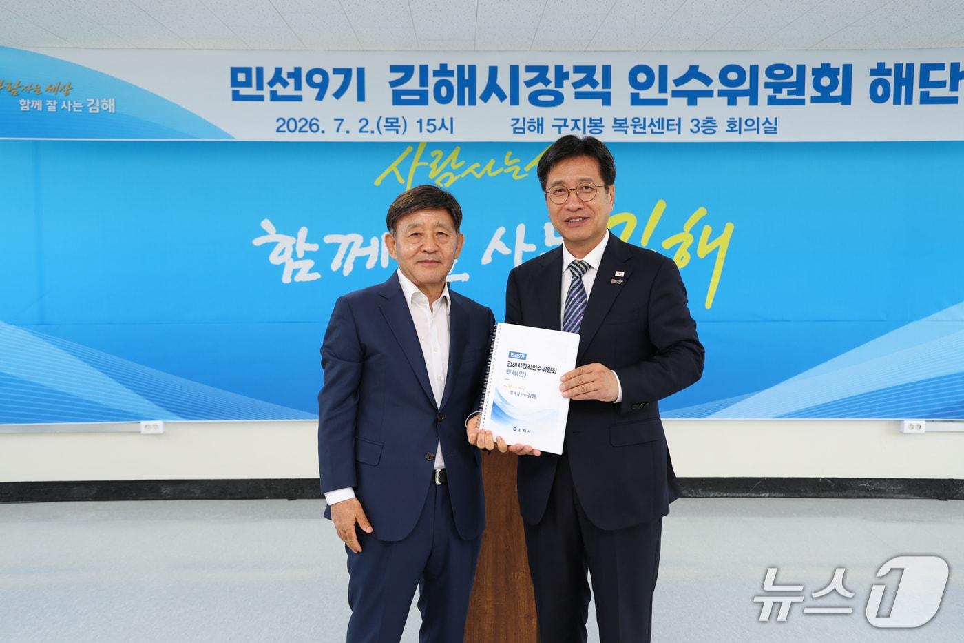 본문 이미지 - 정영두 김해시장(오른쪽)이 2일 김해시장직 인수위원회 해단식에서 허성곤 인수위원장에게 인수위 백서를 전달 받고 있다.(김해시장직 인수위원회 제공. 재판매 및 DB금지)