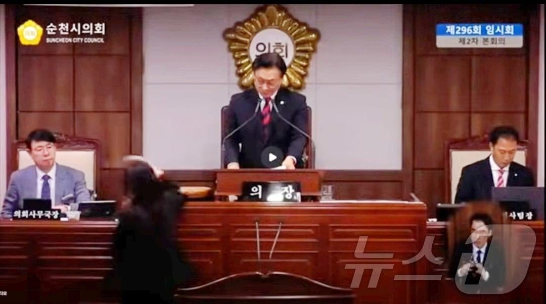 본문 이미지 - 순천시의회 296회 임시회 2차 본회의 도중 정수진 민주당 의원이 의장석에 있는 의사봉을 들고 회의장을 나가고 있다. (순천시의회 방송 갈무리. 재판매 및 DB금지) ⓒ 뉴스1