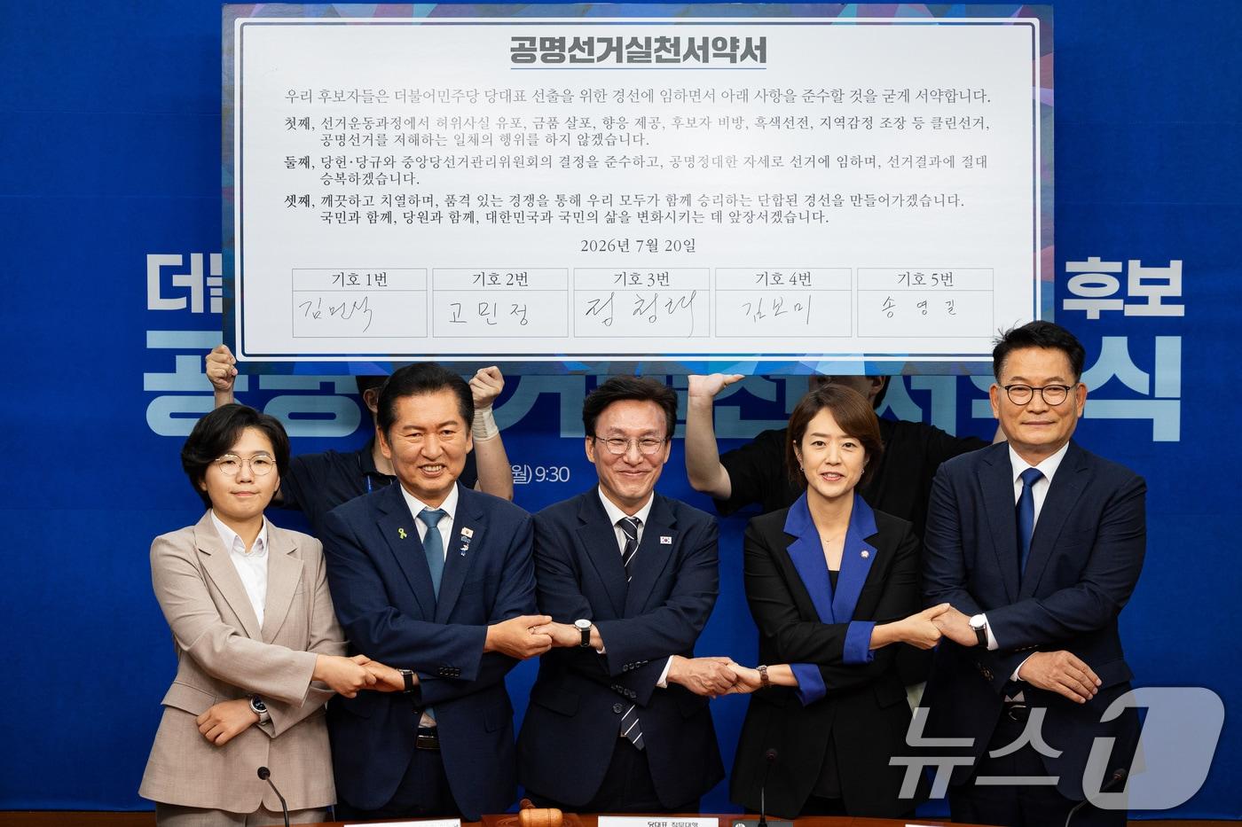 본문 이미지 - 더불어민주당 8·17 전당대회 당대표 후보들이 20일 서울 여의도 국회에서 열린 공명선거 실천 서약식에서 서약서에 서명 후 기념 촬영을 하고 있다. 왼쪽부터 김보미, 정청래, 김민석, 고민정, 송영길 후보. 2026.7.20 ⓒ 뉴스1 유승관 기자