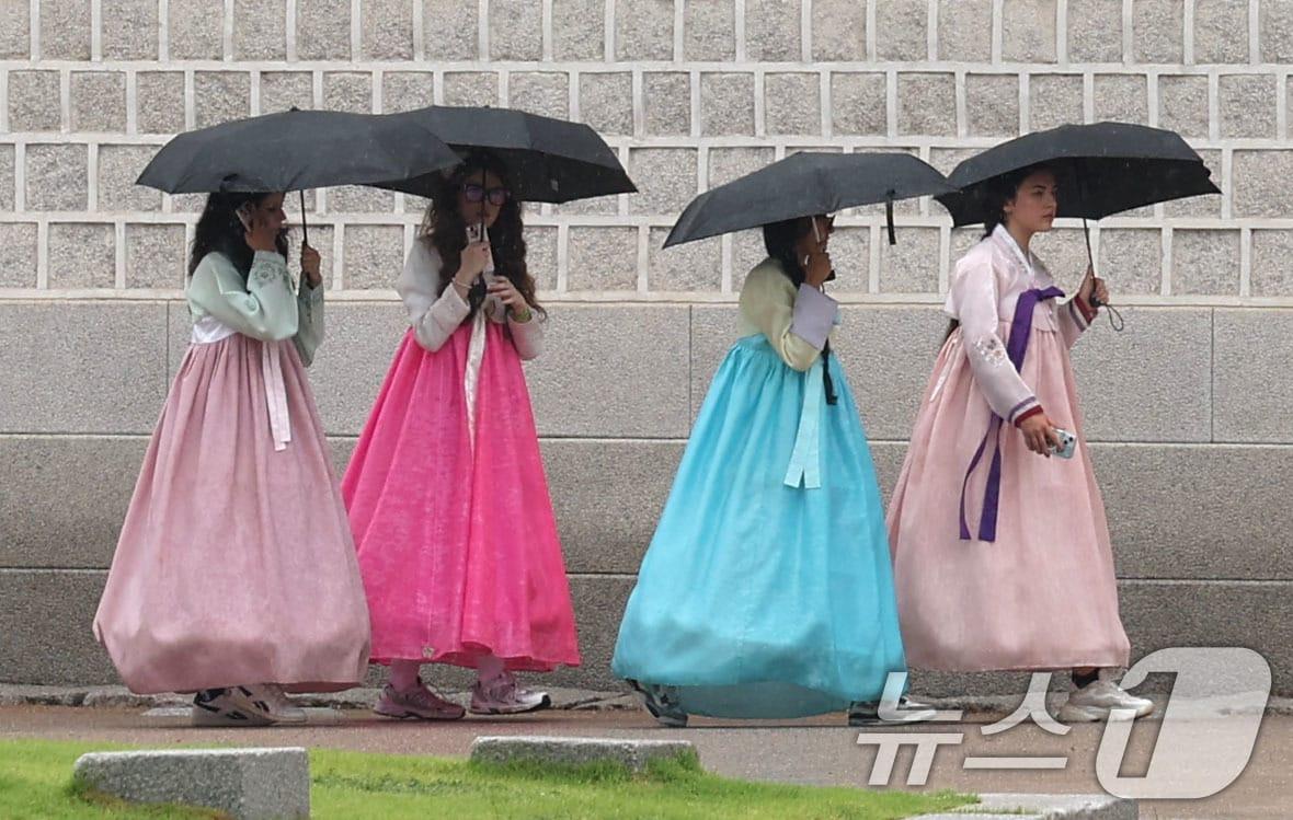 본문 이미지 - 비가 내리는 20일 서울 중구 광화문 앞에서 외국인 관광객들이 우산을 쓰고 이동하고 있다. 2026.7.20 ⓒ 뉴스1 이종수 기자