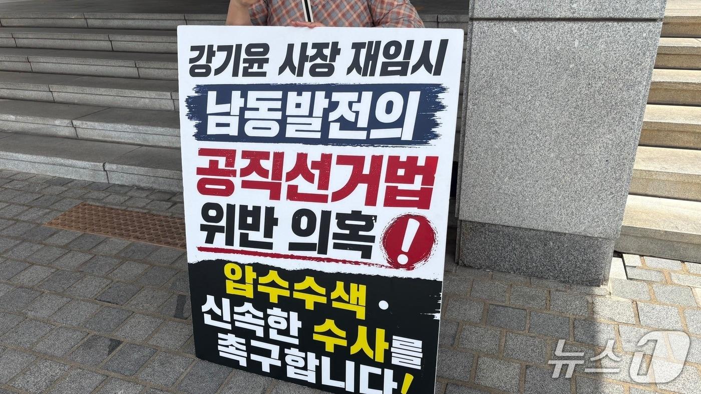 본문 이미지 - 20일 경남경찰청 앞에서 경남 창원지역 한 시민단체 회원이 한국남동발전의 공직선거법 위반 의혹에 대해 신속 수사를 촉구하는 피켓 시위를 하고 있다.2026.7.20/뉴스1 강정태 기자