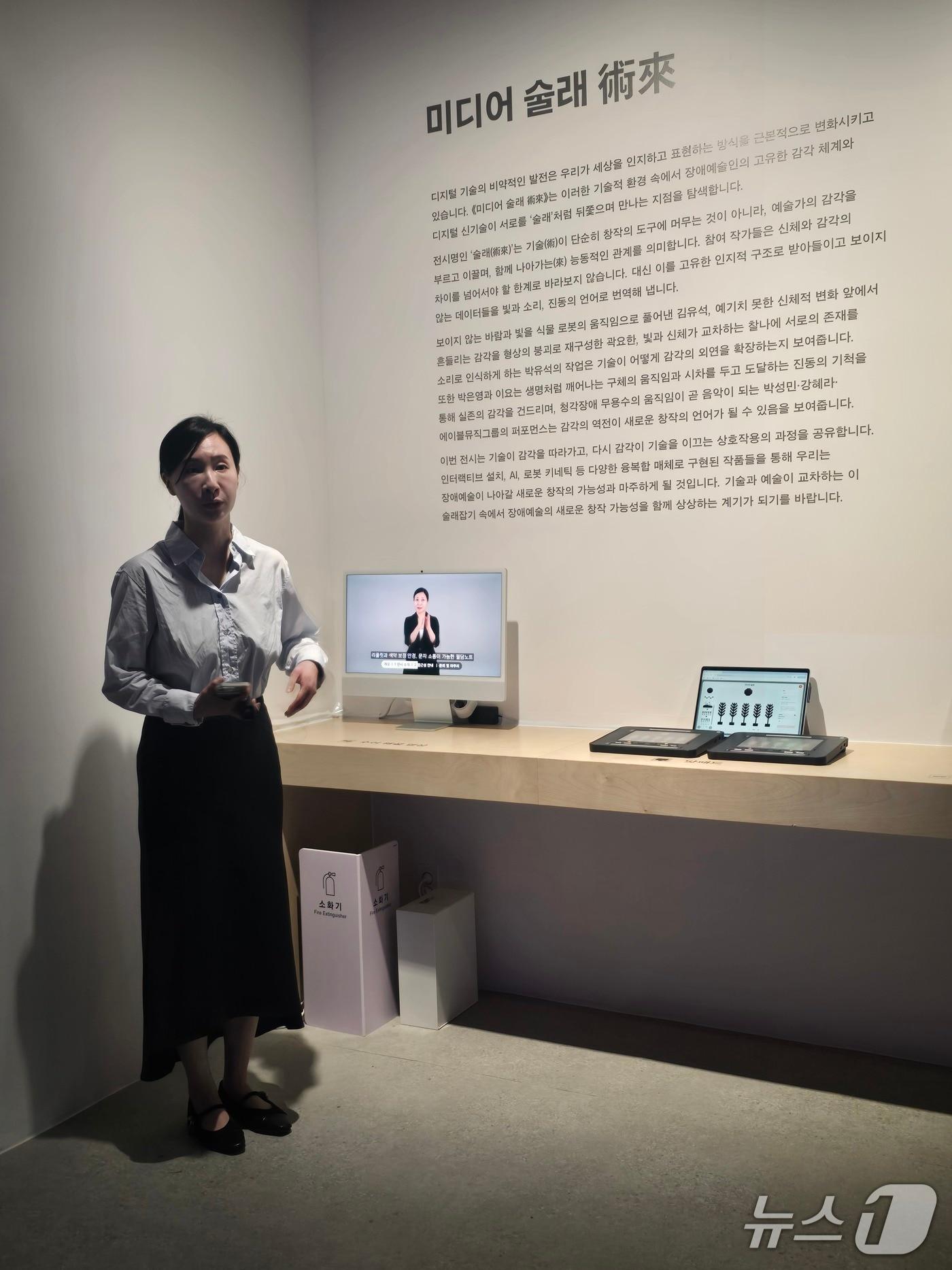 본문 이미지 - 20일 기자간담회가 진행된 '미디어 술래'전 전시 전경. 최인경 대리가 도슨트를 진행하 있다. ⓒ 뉴스1 김정한 기자