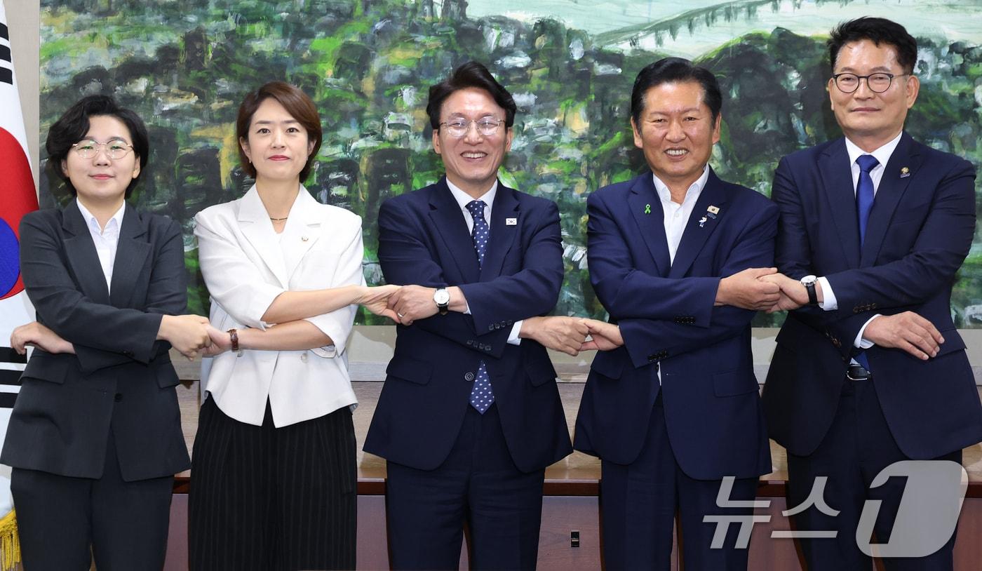 본문 이미지 - 더불어민주당 당권에 도전하는 김보미(왼쪽부터)·고민정·김민석·정청래·송영길 후보가 21일 서울 중구 서울시의회에서 열린 당대표 후보자 초청 간담회에 앞서 손을 맞잡은 채 기념촬영을 하고 있다. 2026.7.21 ⓒ 뉴스1 오대일 기자