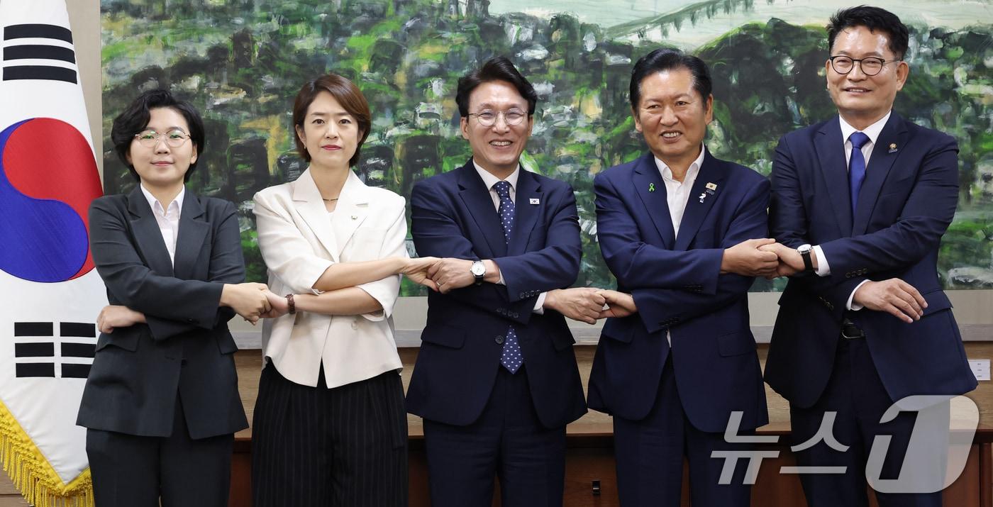 본문 이미지 - 더불어민주당 당권에 도전하는 김보미(왼쪽부터)·고민정·김민석·정청래·송영길 후보가 21일 서울 중구 서울시의회에서 열린 당대표 후보자 초청 간담회에 앞서 손을 맞잡은 채 기념촬영을 하고 있다. 2026.7.21 ⓒ 뉴스1 오대일 기자