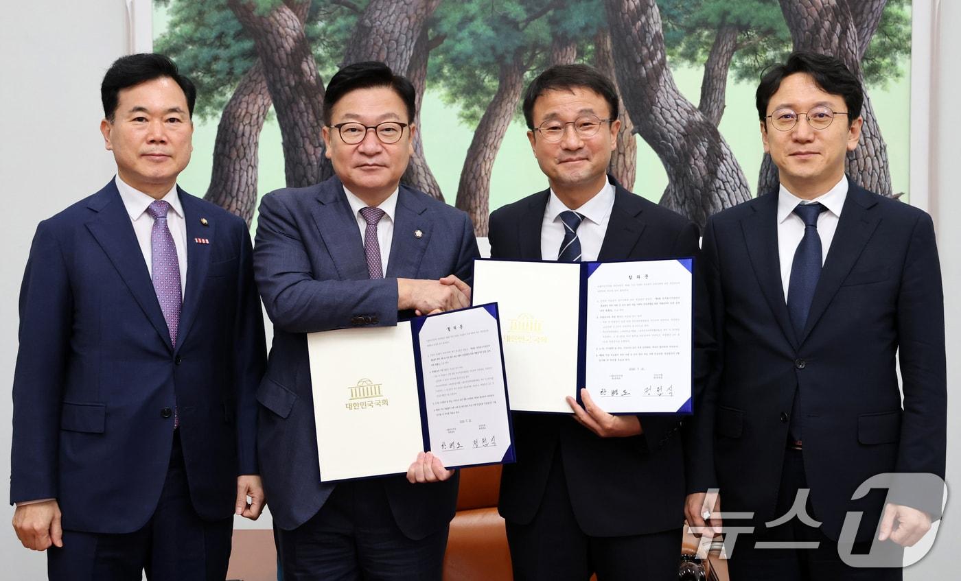 본문 이미지 - 한병도 더불어민주당 대표 직무대행 겸 원내대표와 정점식 국민의힘 원내대표가 21일 서울 여의도 국회 운영위원장실에서 제9회 전국동시지방선거 투표용지 부족 사태 등 선거관리 부실 사태의 진상규명을 위한 특별검사의 임명 등에 관한 법률안 합의문에 서명한 후 악수하고 있다. 왼쪽부터 김승수 국민의힘 원내수석부대표, 정 원내대표, 한 직무대행, 천준호 더불어민주당 원내운영수석부대표. (공동취재) 2026.7.21 ⓒ 뉴스1 신웅수 기자