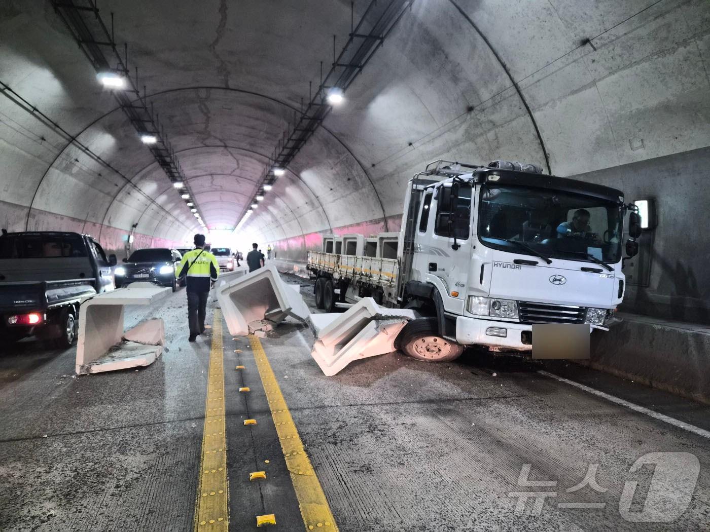 본문 이미지 - 21일 오전 9시 45분쯤 전남광주통합특별시 장흥군 용산면 자울재터널(장흥방면)에서 SUV가 중앙선을 넘어 마주오던 5톤 화물차 운전석 측면을 들이받아 콘크리트 구조물이 떨어지며 차량 통행이 통제된 모습. (전남광주통합소방본부 제공. 재판매 및 DB 금지) 