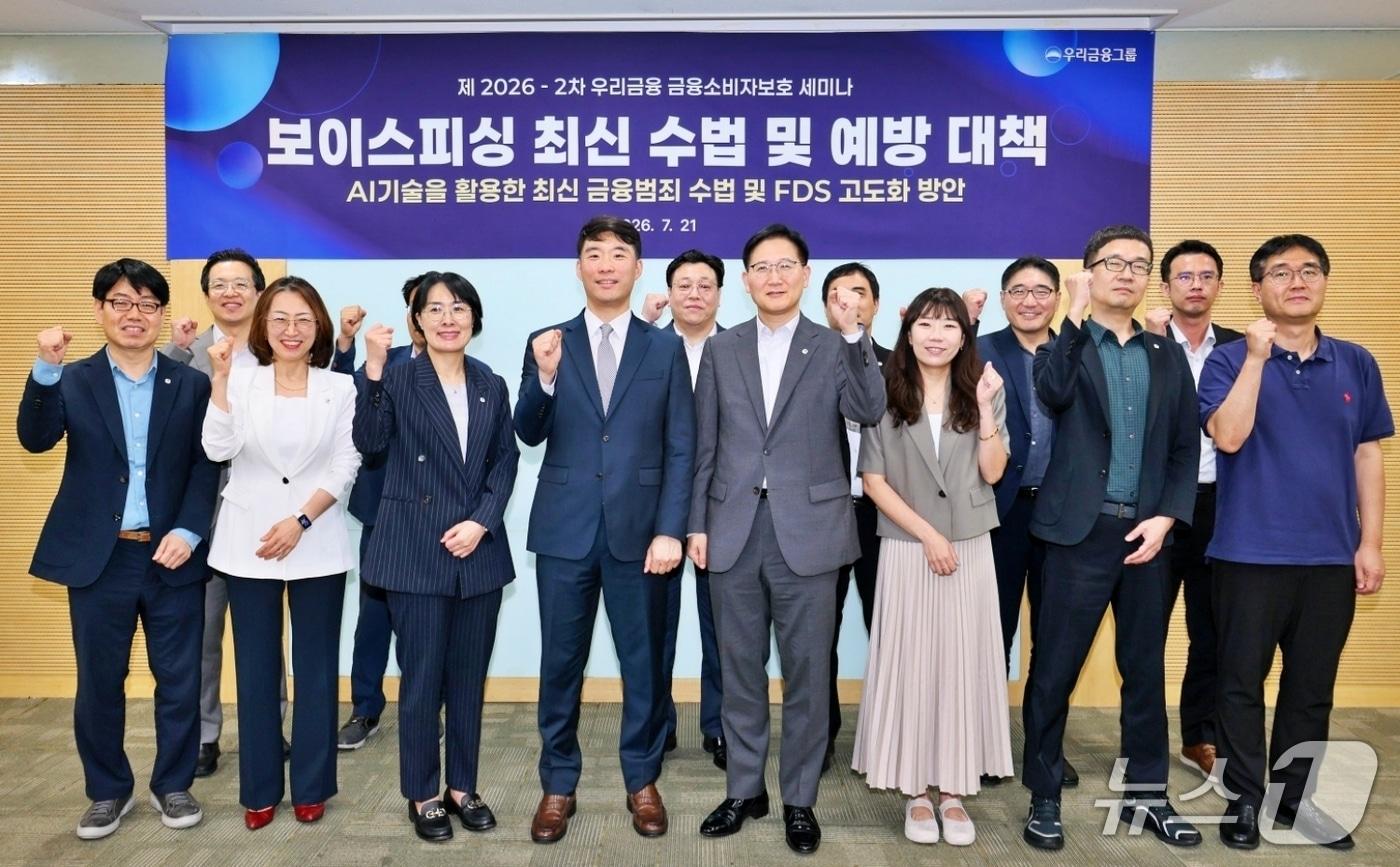 본문 이미지 - 우리금융그룹은 21일 서울 회현동 본점에서 그룹사 소비자보호·FDS·IT 등 주요 부서 임직원 60여 명이 참석한 가운데 '금융소비자보호 세미나'를 개최했다. (앞줄 왼쪽 네번째) 경찰청 전기통신금융사기 통합대응단 박상현 경정, (앞줄 왼쪽 다섯번째) 우리금융그룹 소비자보호부문장 고원명 상무 등 그룹 소비자보호 및 FDS 담당 부서장들이 기념촬영을 하고 있다. 2026.07.21 / 사진제공=우리금융그룹